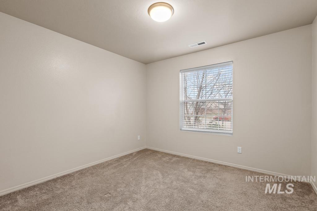 Empty room with light colored carpet and baseboards
