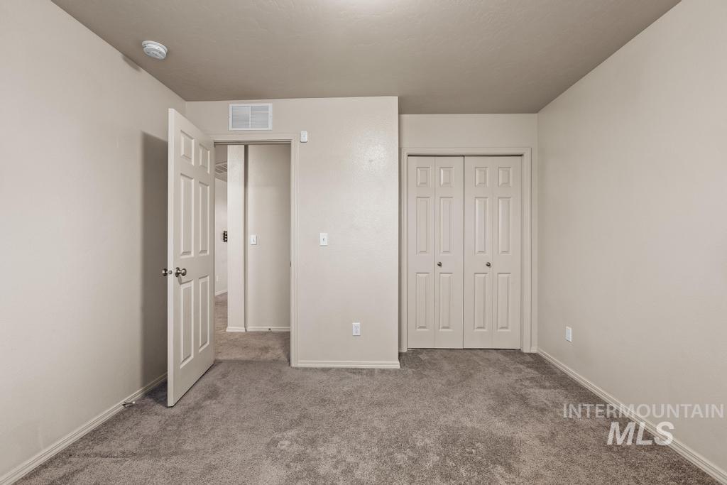 Unfurnished bedroom featuring carpet flooring and a closet