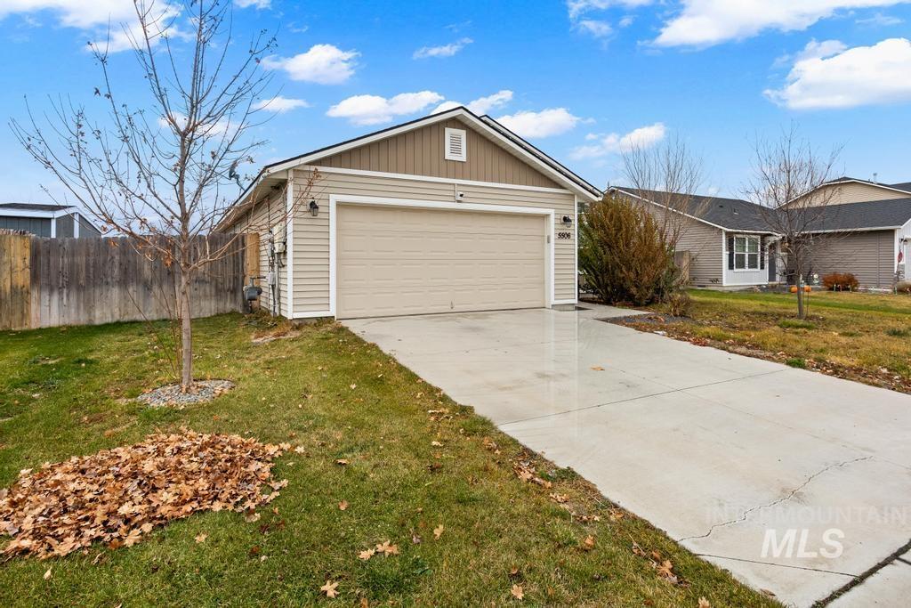 Ranch-style house featuring driveway, board and batten siding, and a garage