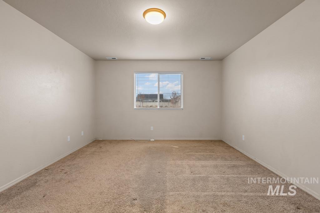 Spare room with light carpet and baseboards