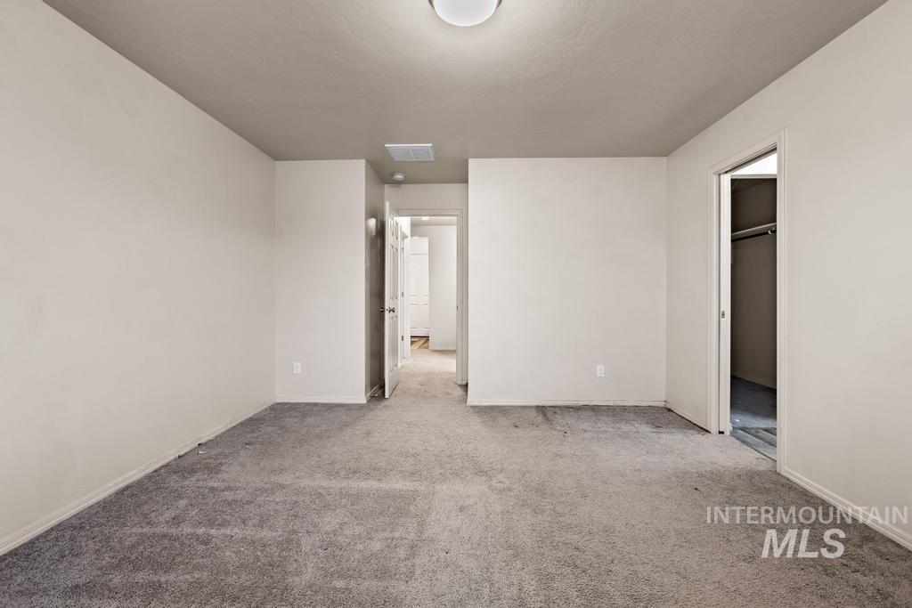 Unfurnished bedroom with carpet and a spacious closet