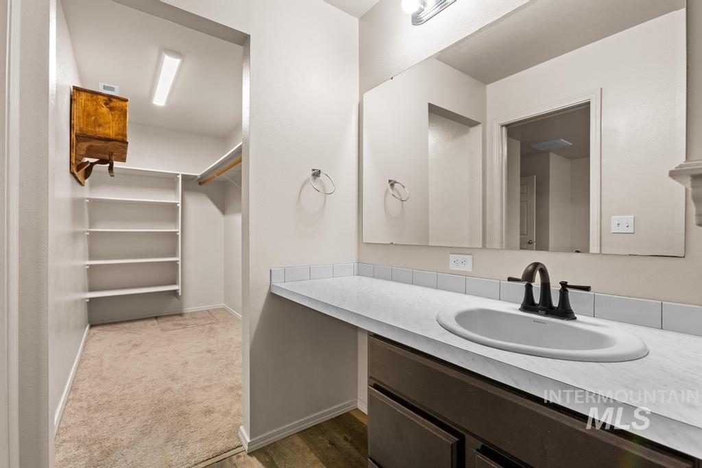 Bathroom with vanity and a spacious closet