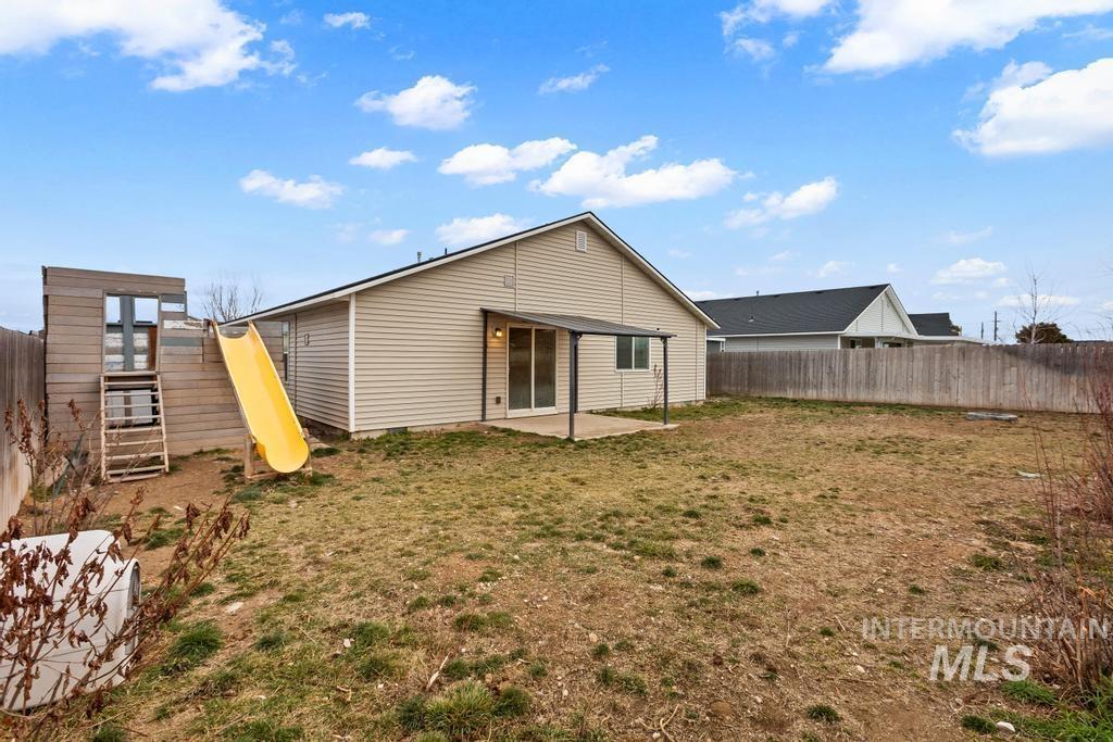 Back of house featuring a patio area, a fenced backyard, and a playground
