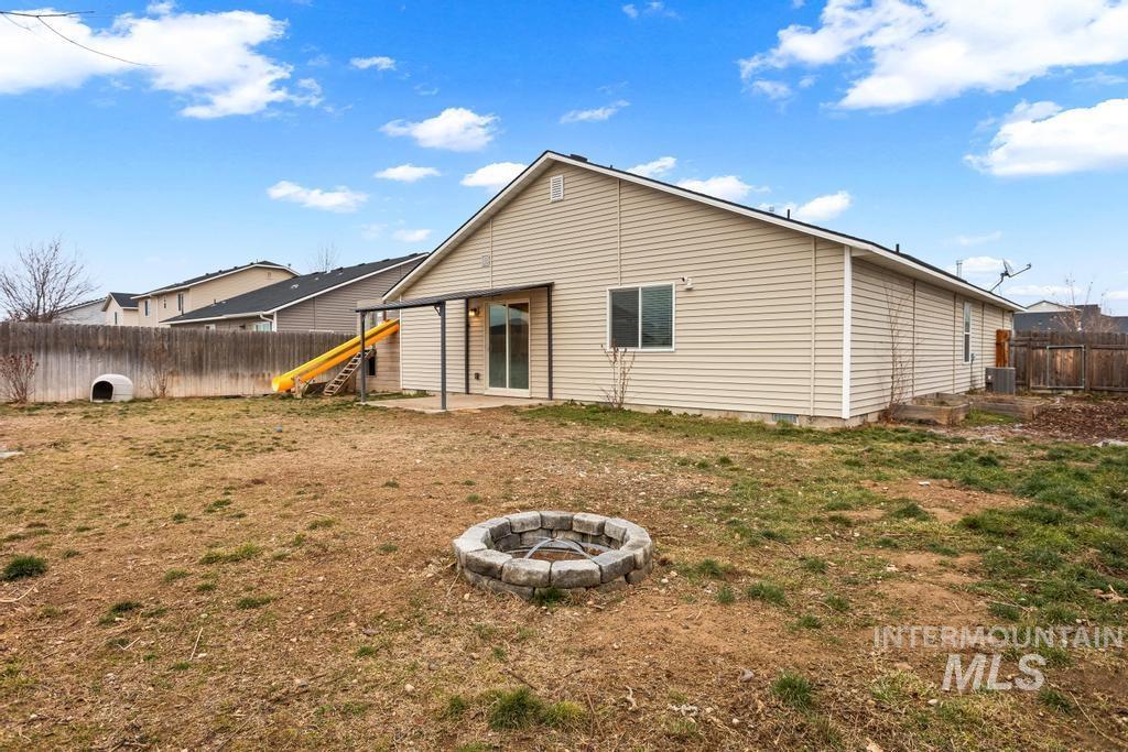 Back of house featuring a patio area, a fenced backyard, and a fire pit