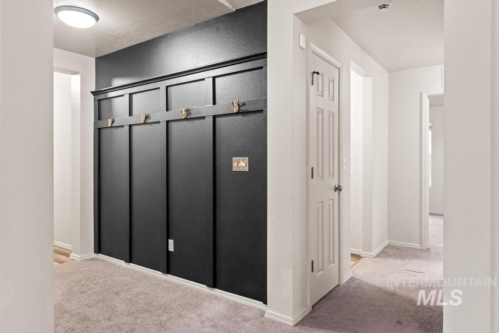 Hall with light carpet and a textured wall