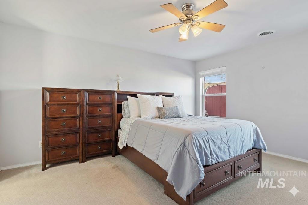 Bedroom featuring light colored carpet and ceiling fan
