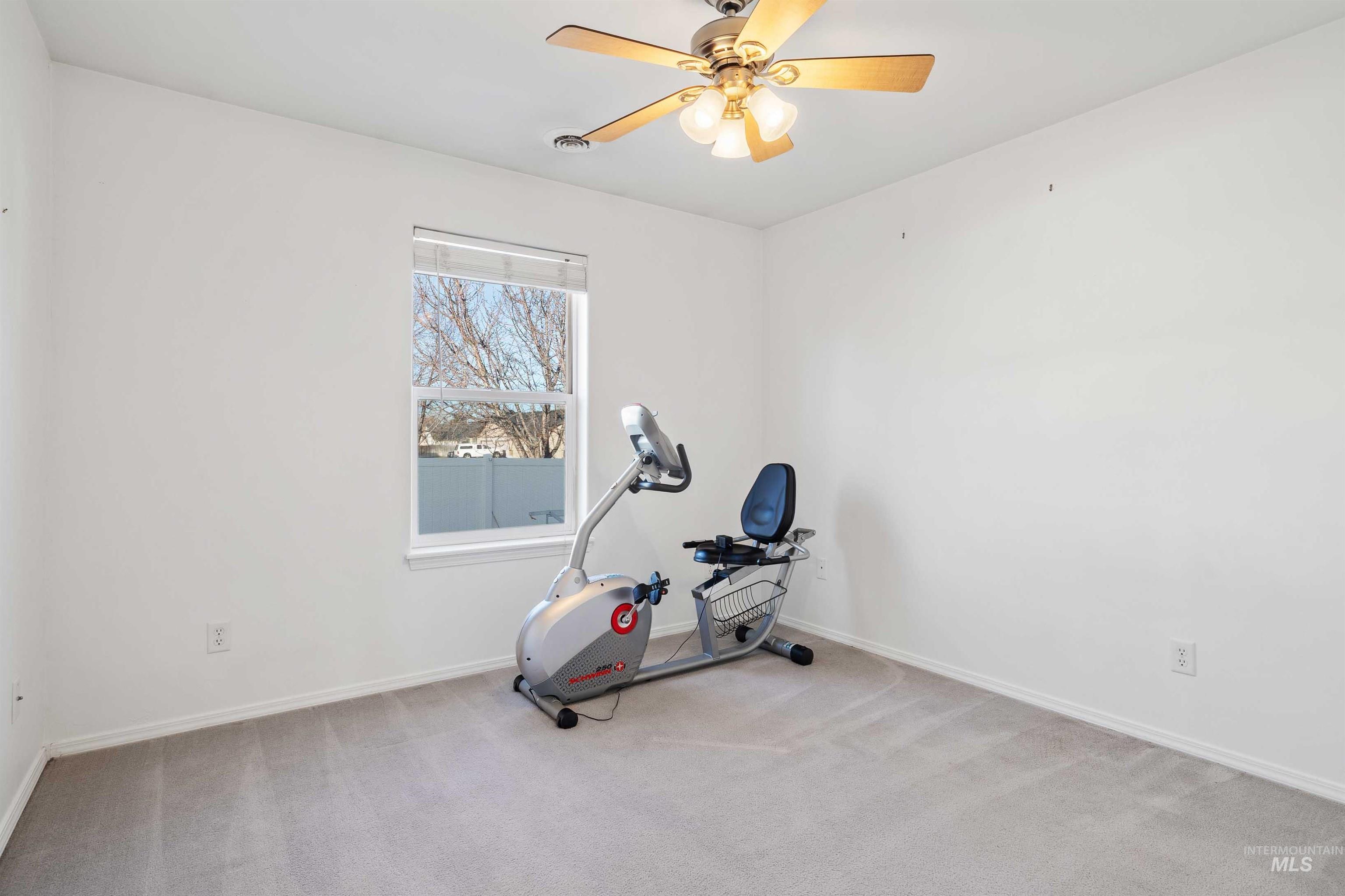 Exercise room with carpet flooring and ceiling fan