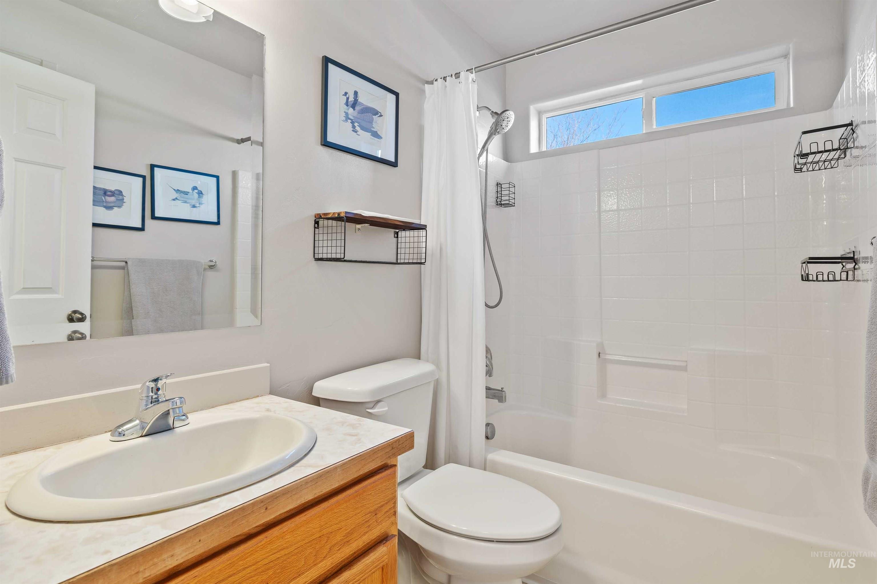 Bathroom featuring vanity and shower / bath combination with curtain