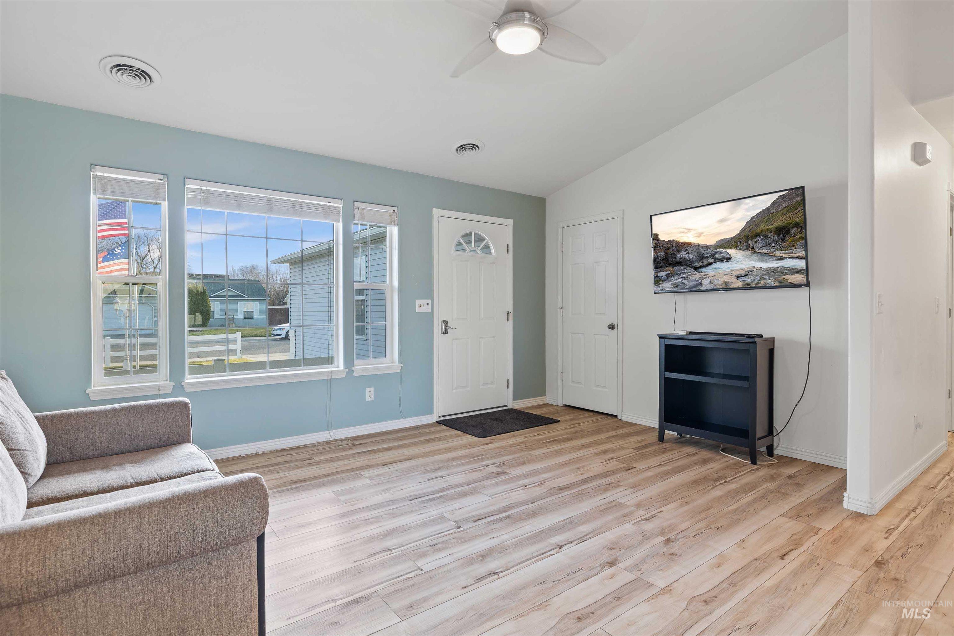 Foyer featuring light wood-style flooring, lofted ceiling, and a ceiling fan