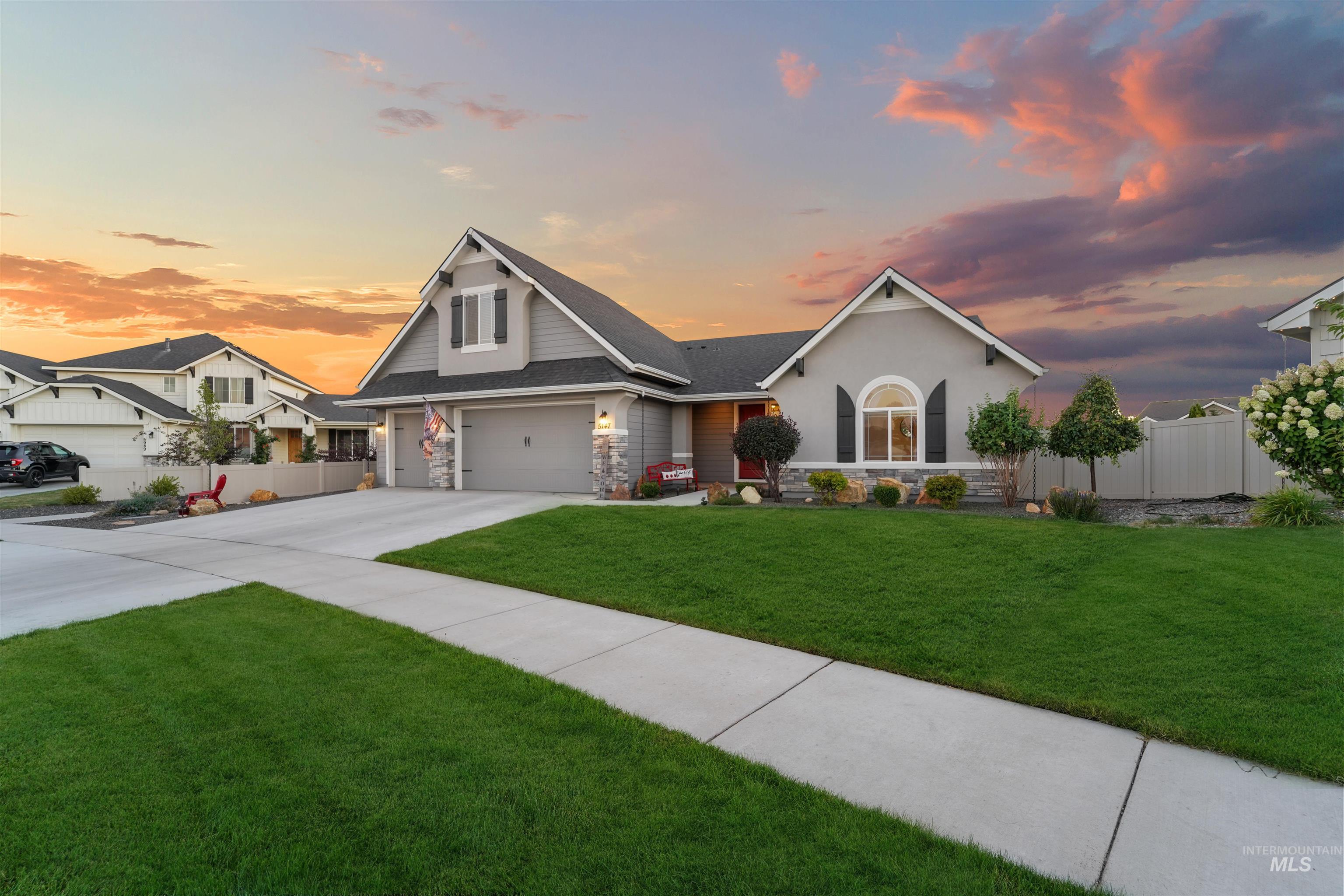 View of front of house featuring stone siding, concrete driveway, a garage, and stucco siding