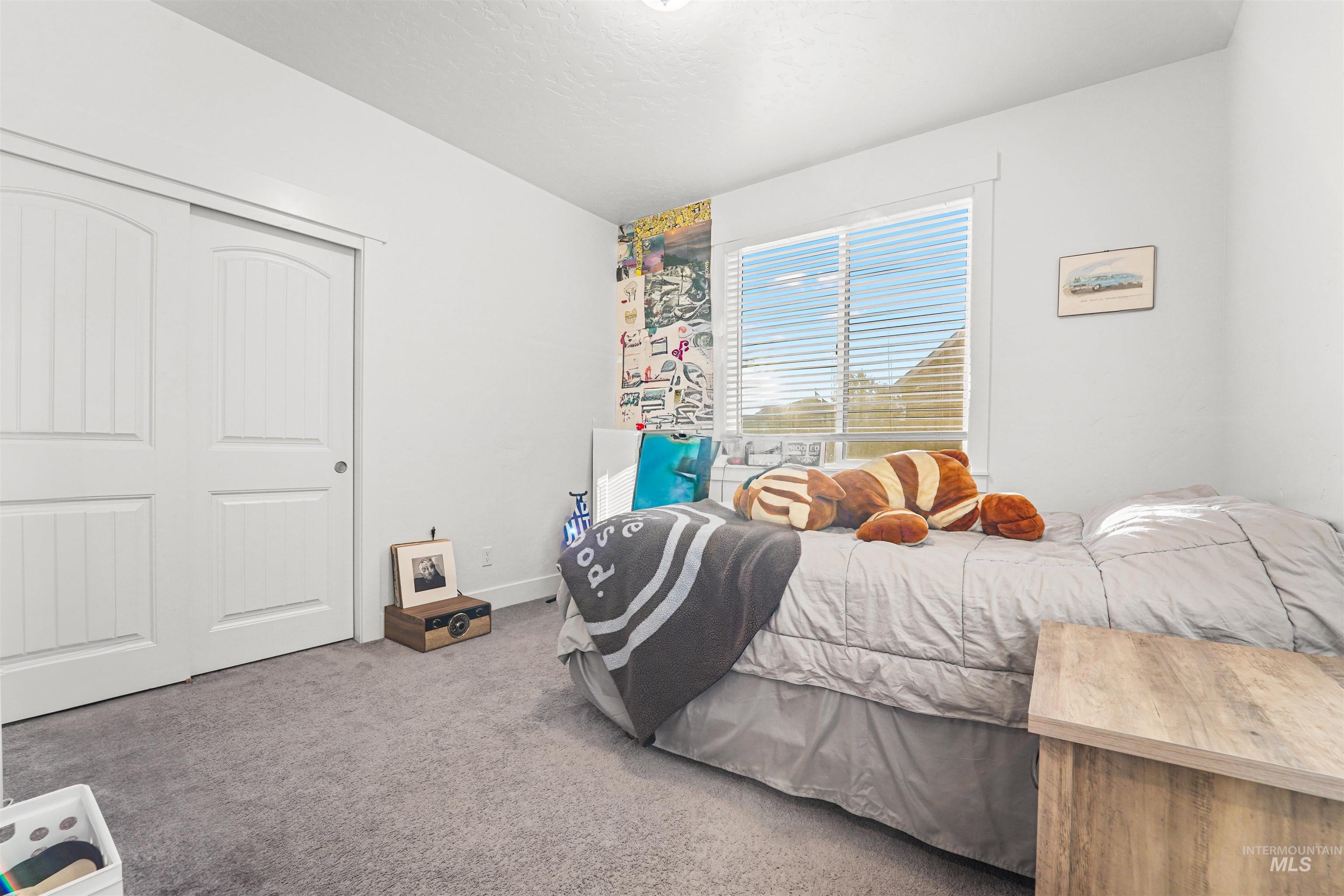 Carpeted bedroom with a closet and baseboards