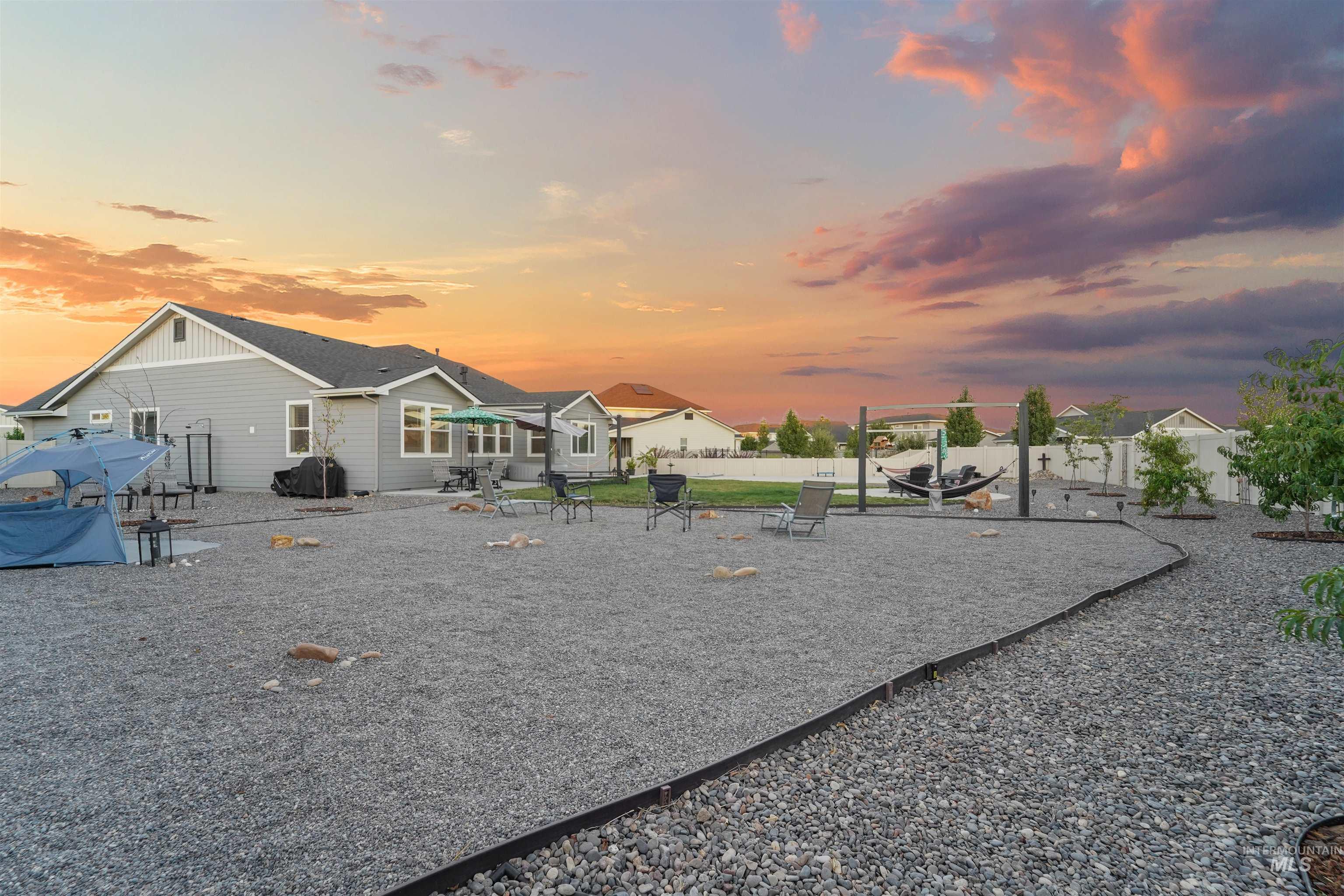 Playground at dusk featuring a patio area, a fenced backyard, and a playground