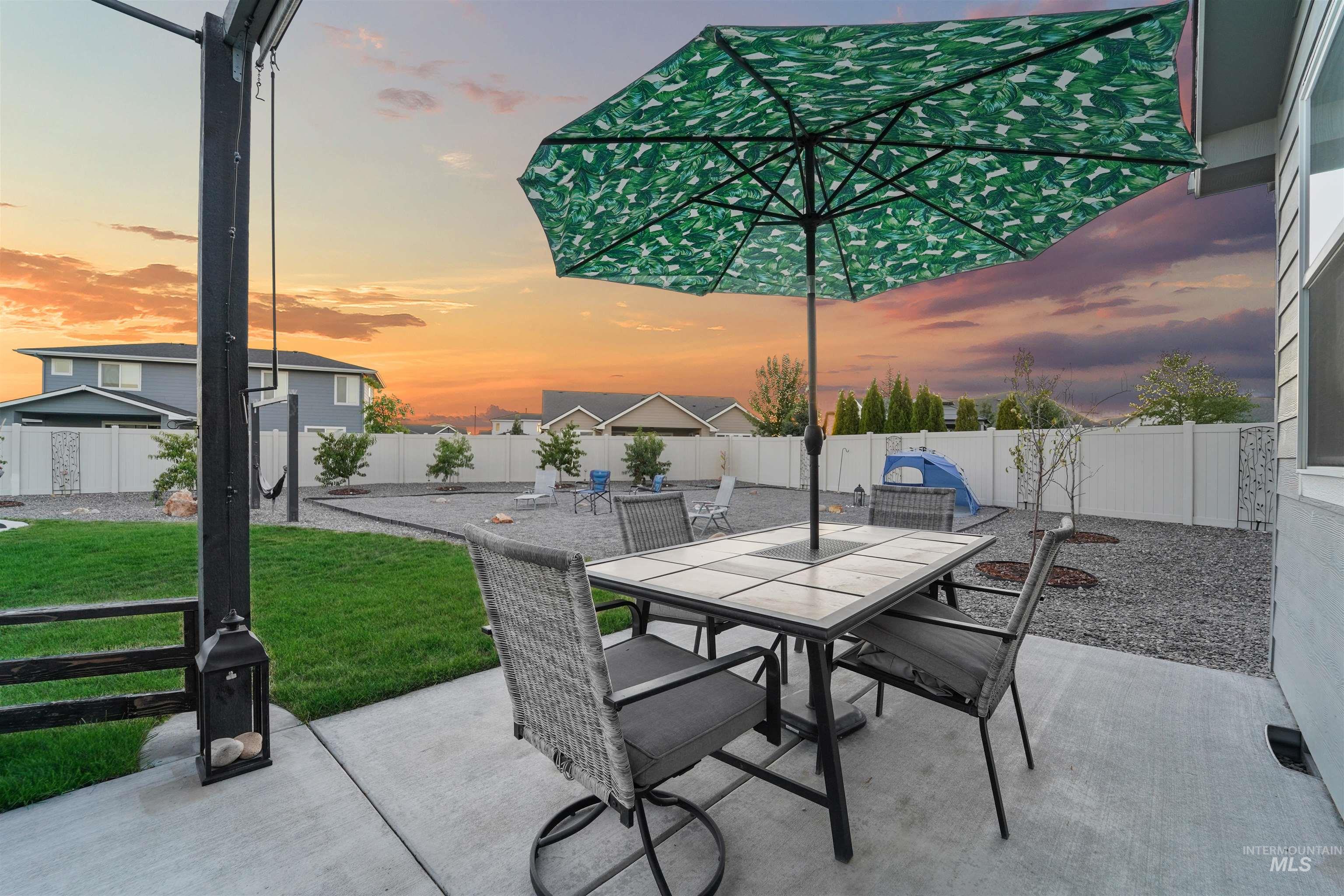 Patio terrace at dusk featuring a patio, a fenced backyard, and outdoor dining space