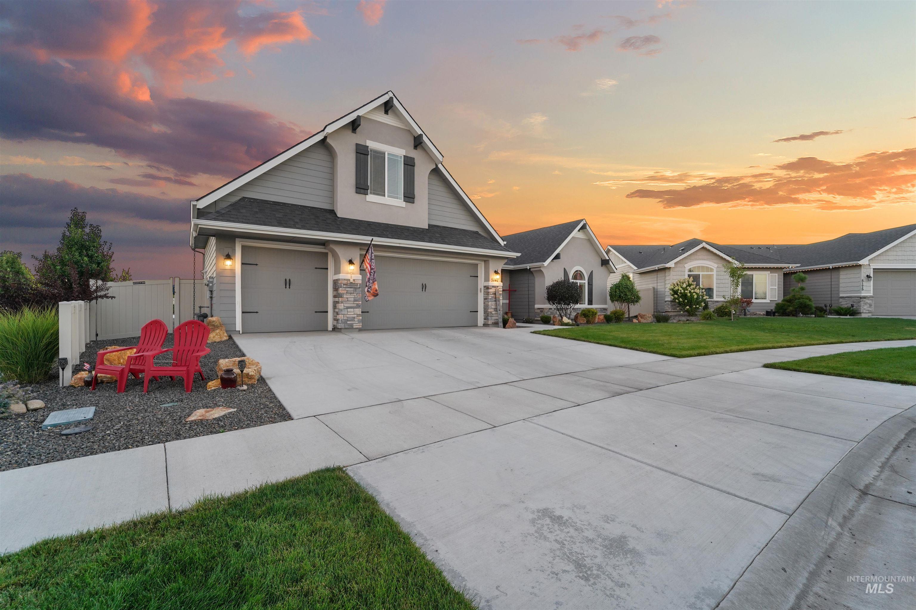 Traditional-style house featuring concrete driveway, stone siding, and an attached garage