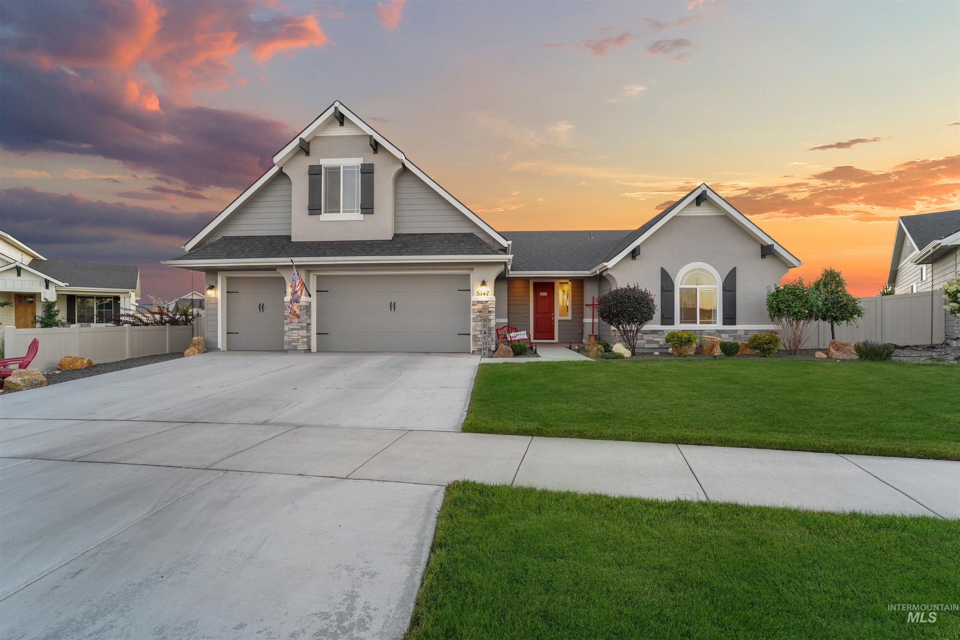 View of front facade with stone siding, driveway, a shingled roof, stucco siding, and an attached garage