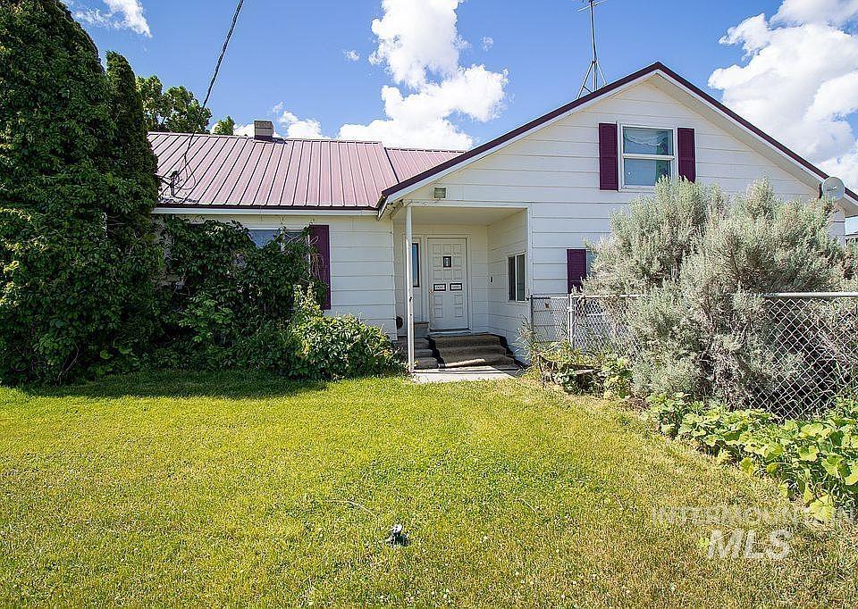 View of front of house with a metal roof and a chimney