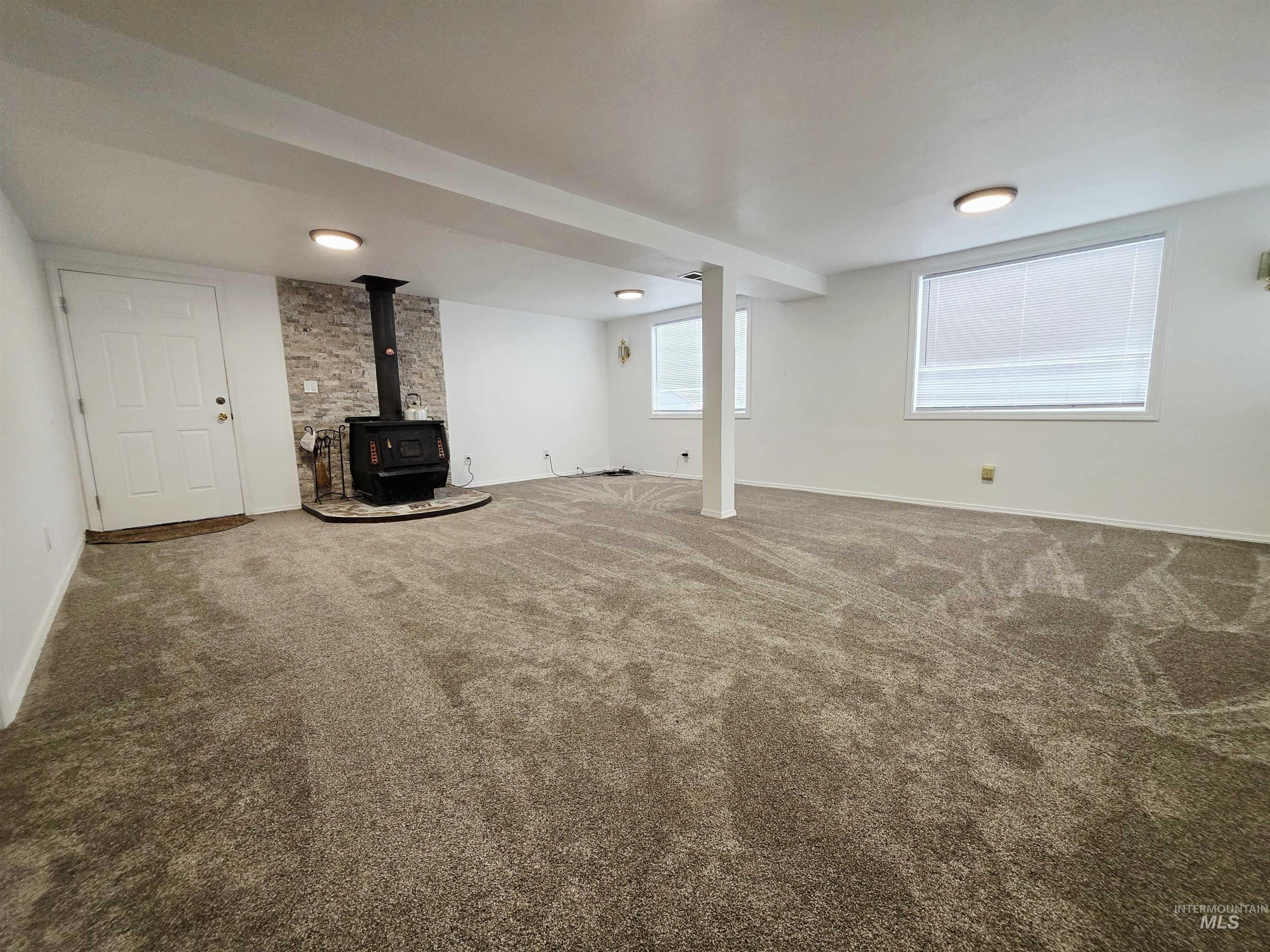 Below grade area with a wood stove and carpet