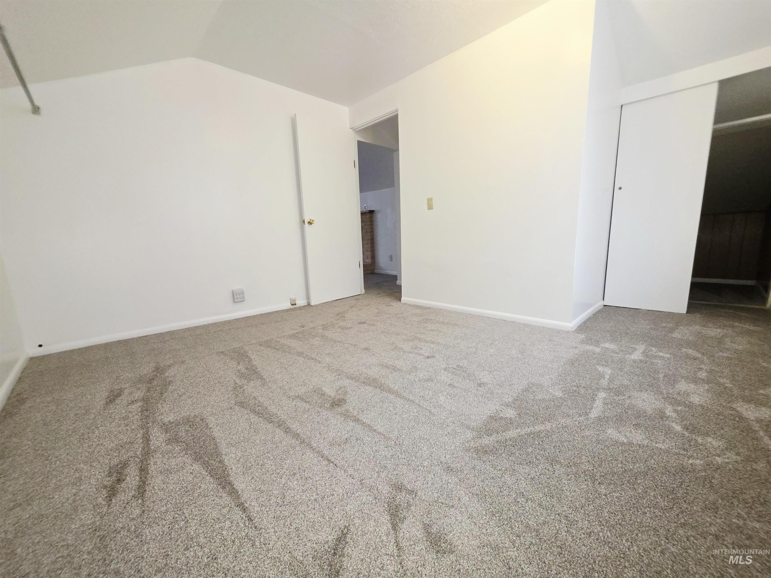 Unfurnished bedroom featuring lofted ceiling, carpet, and a closet