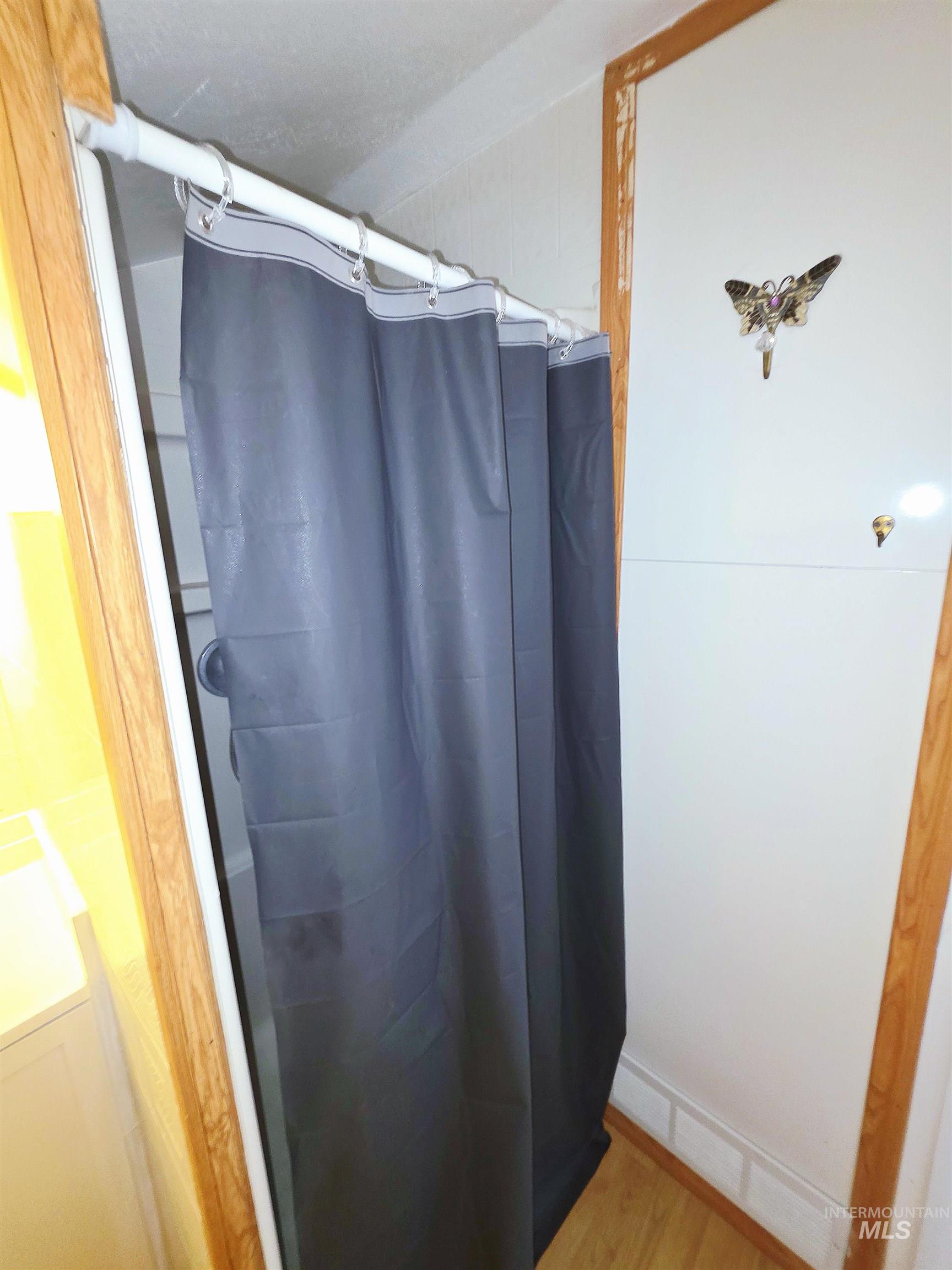 Full bath featuring a shower with shower curtain and light wood-type flooring