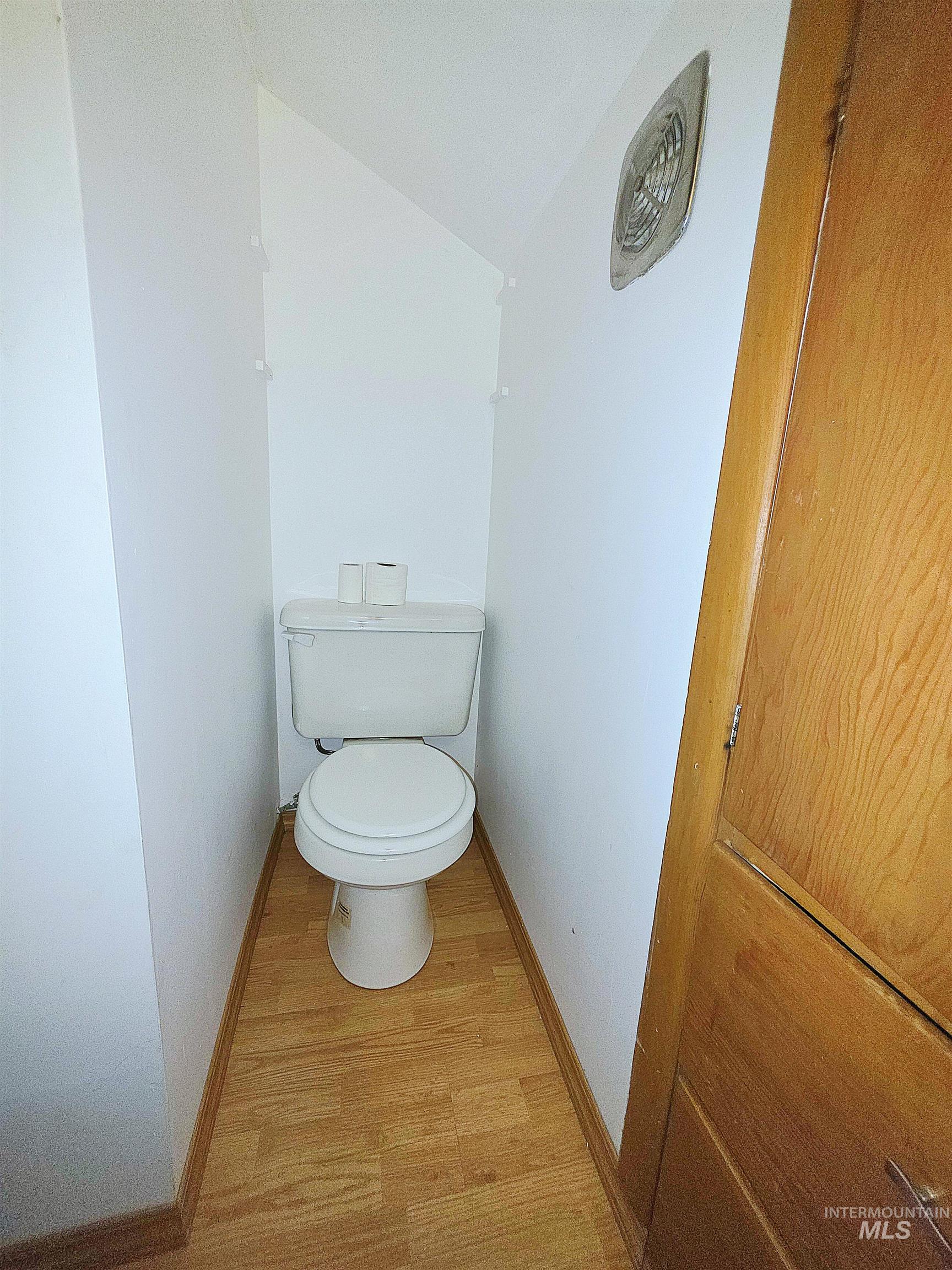 Bathroom with toilet and light wood-style floors