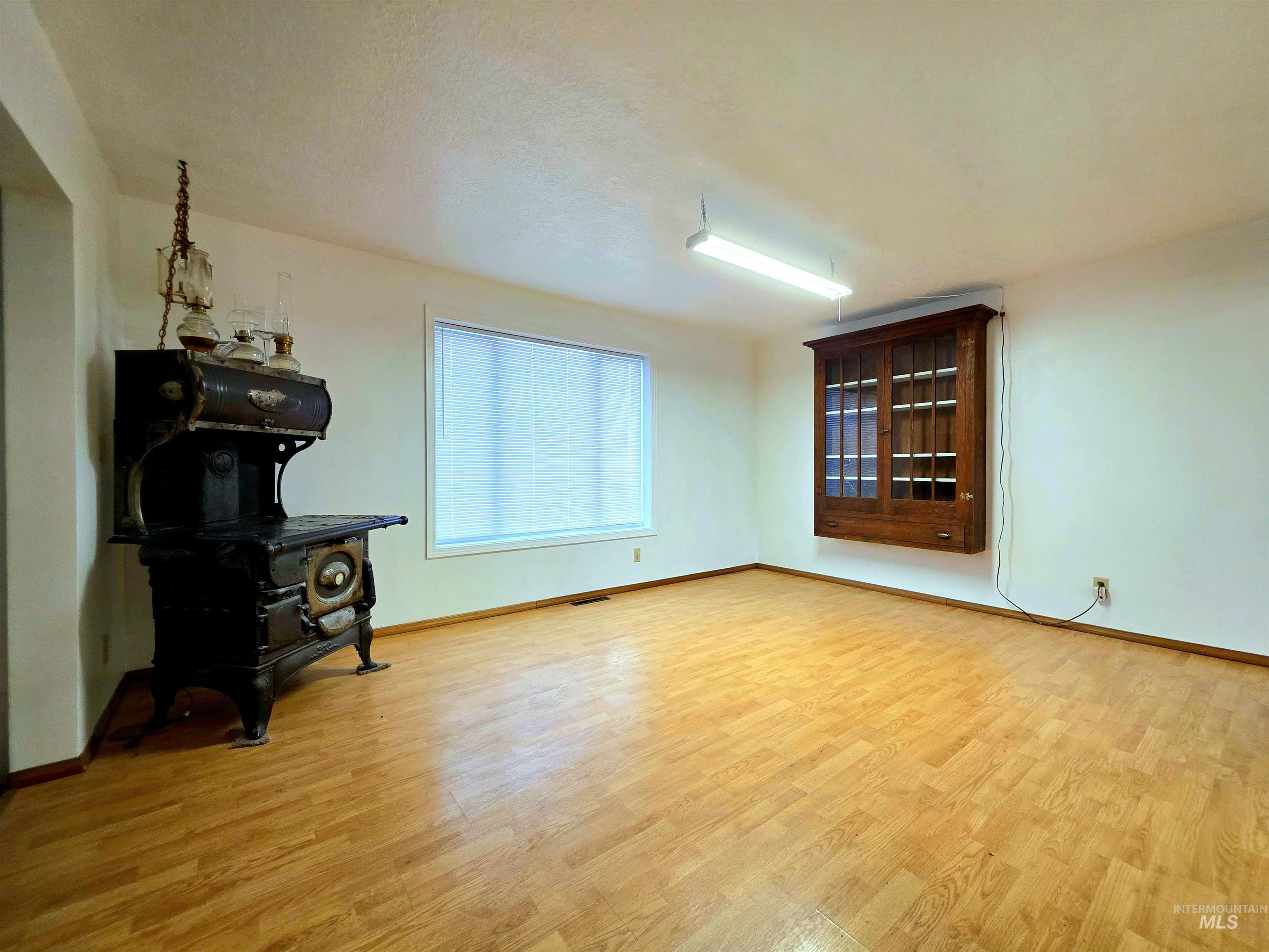 Living area featuring light wood-type flooring and a textured ceiling