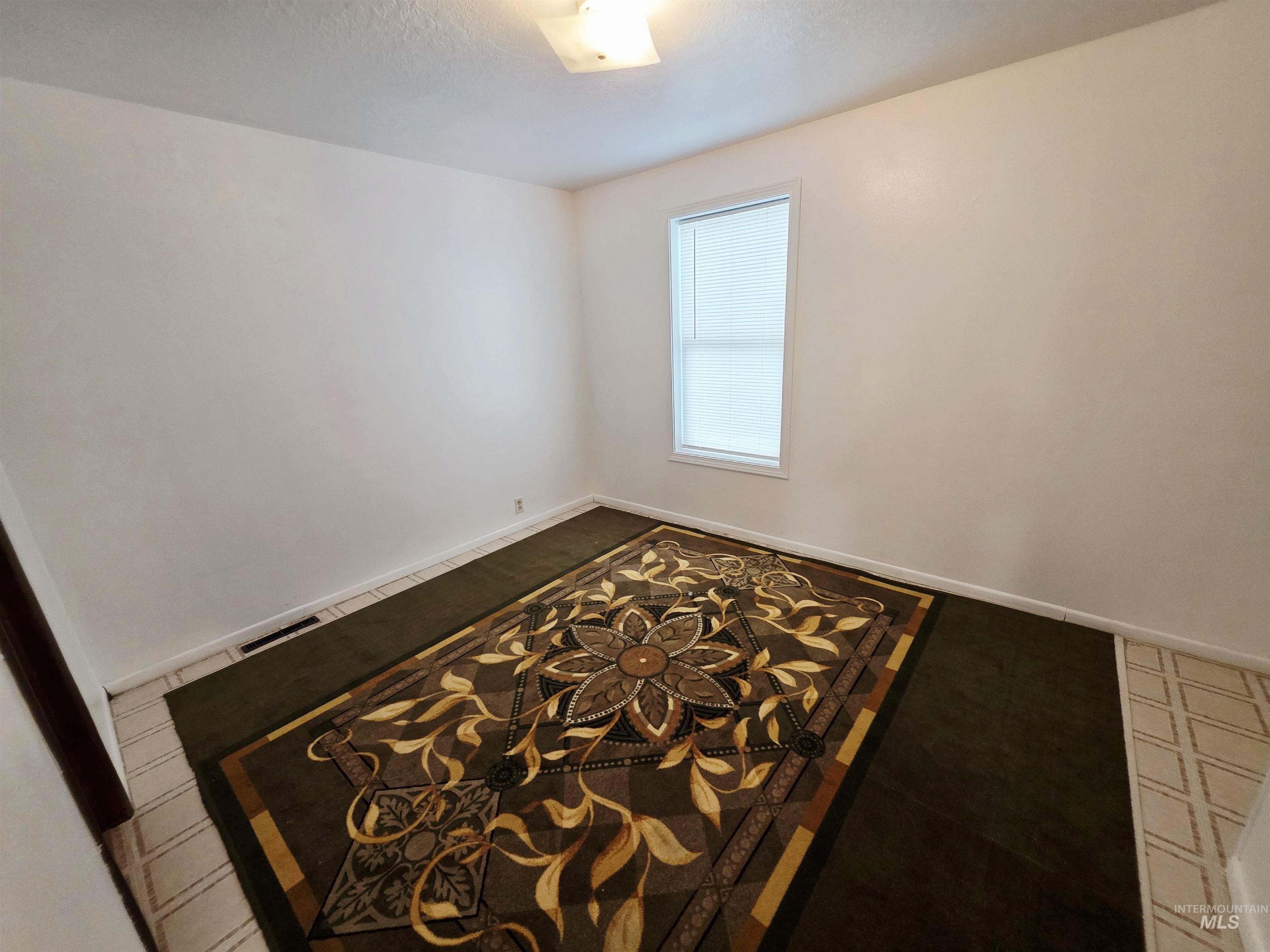 Spare room featuring a textured ceiling and baseboards