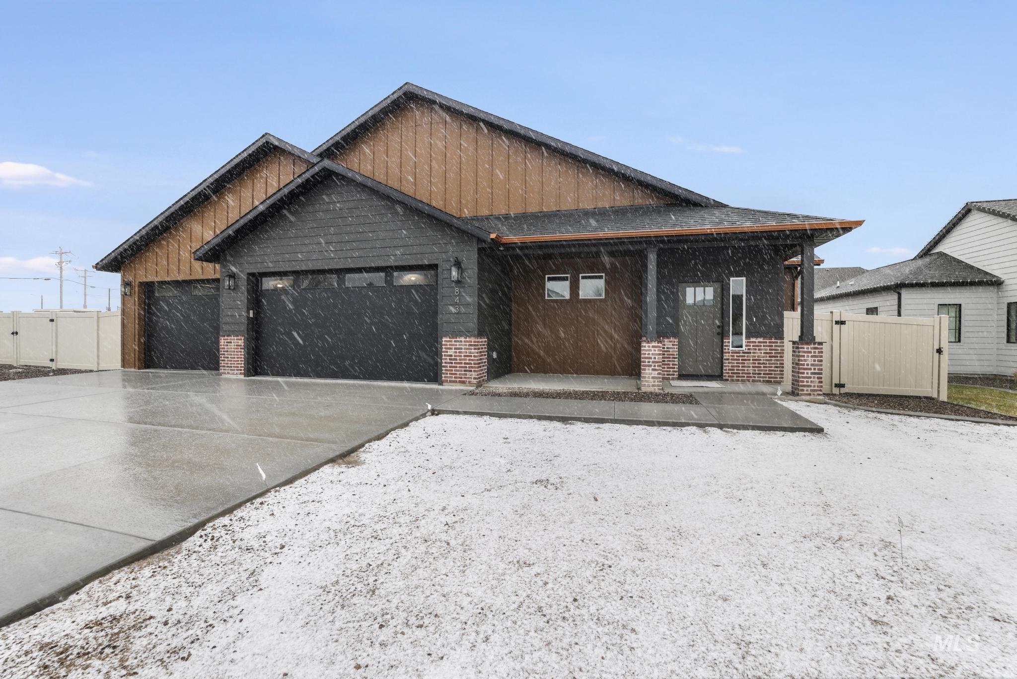 View of front facade with an attached garage, concrete driveway, and brick siding