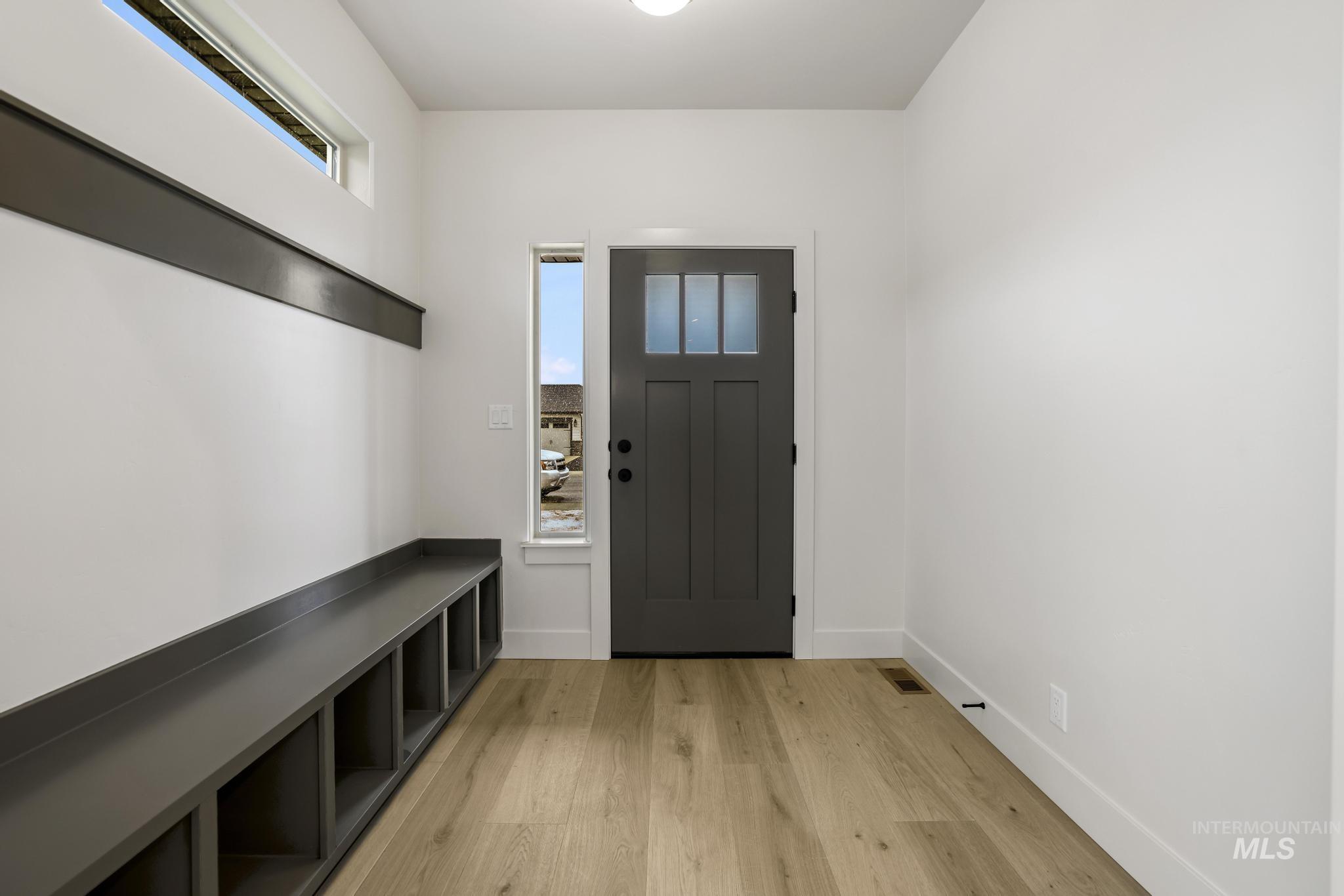 Foyer entrance featuring light wood-style flooring and baseboards