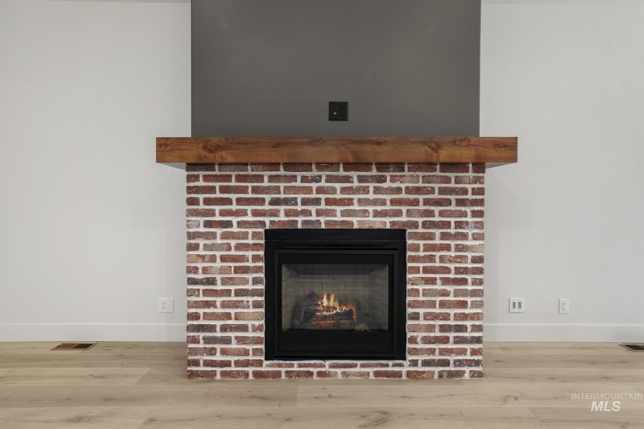 Detailed view of a brick fireplace and wood finished floors