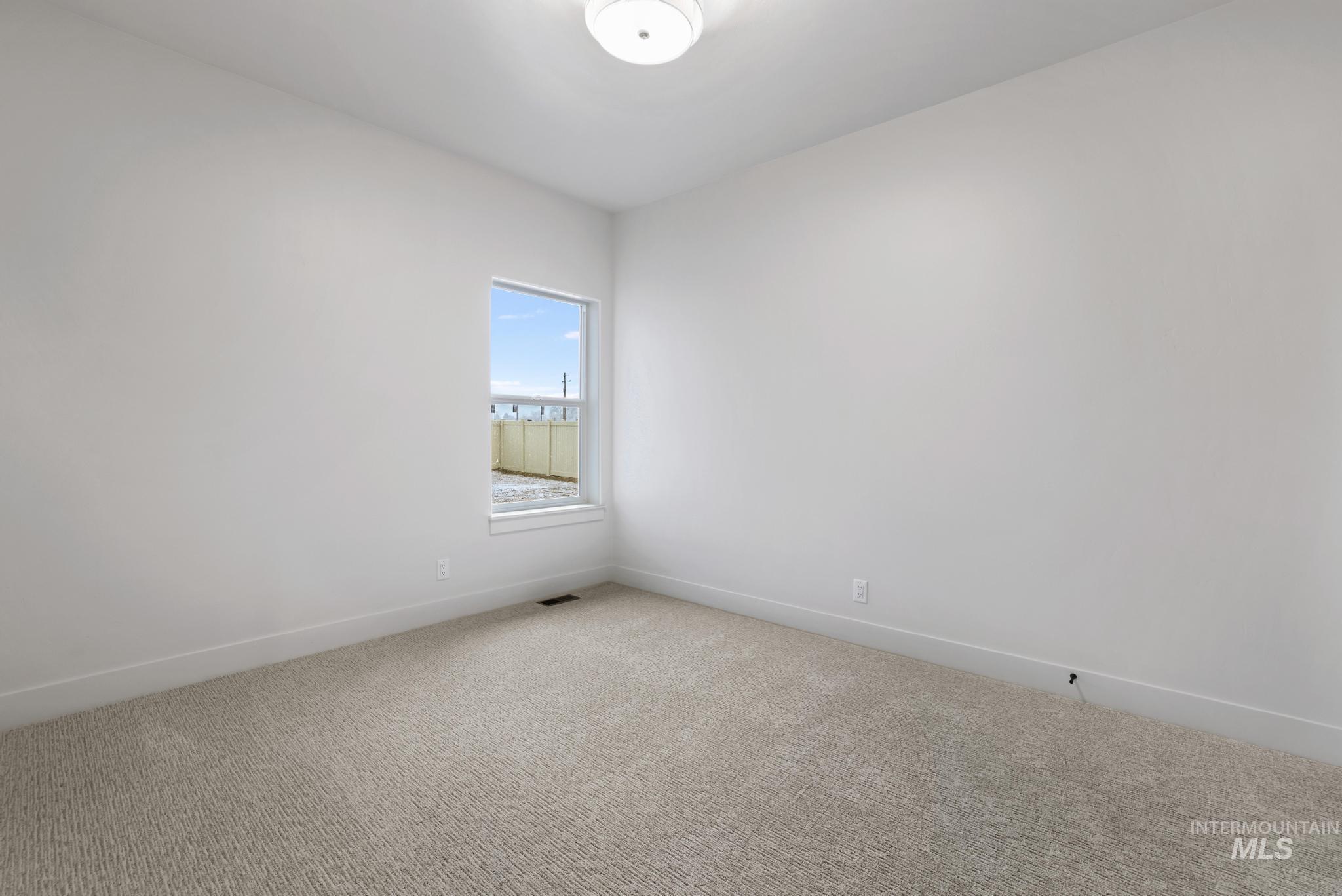 Carpeted empty room with baseboards