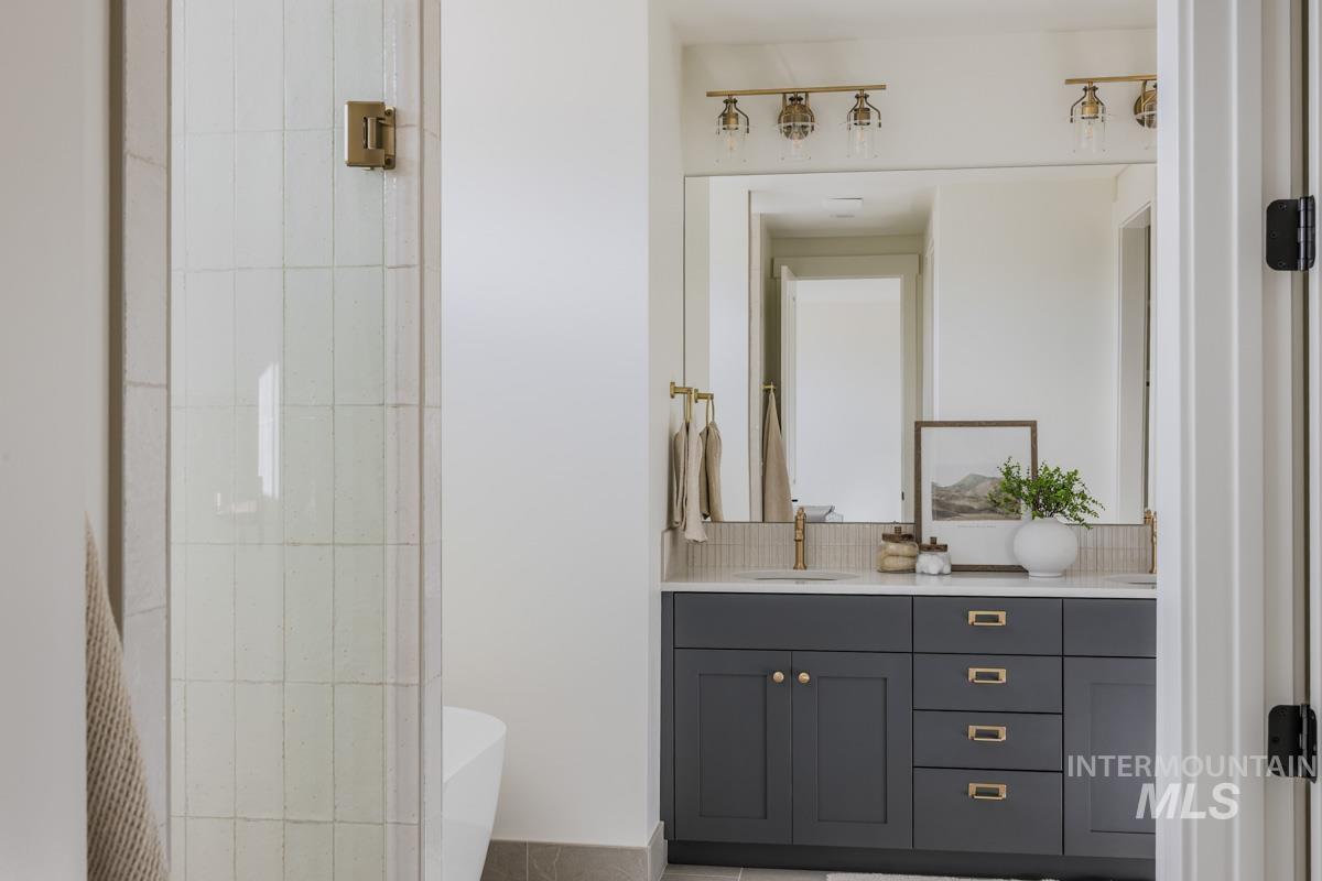 Full bath with double vanity, a soaking tub, and tasteful backsplash