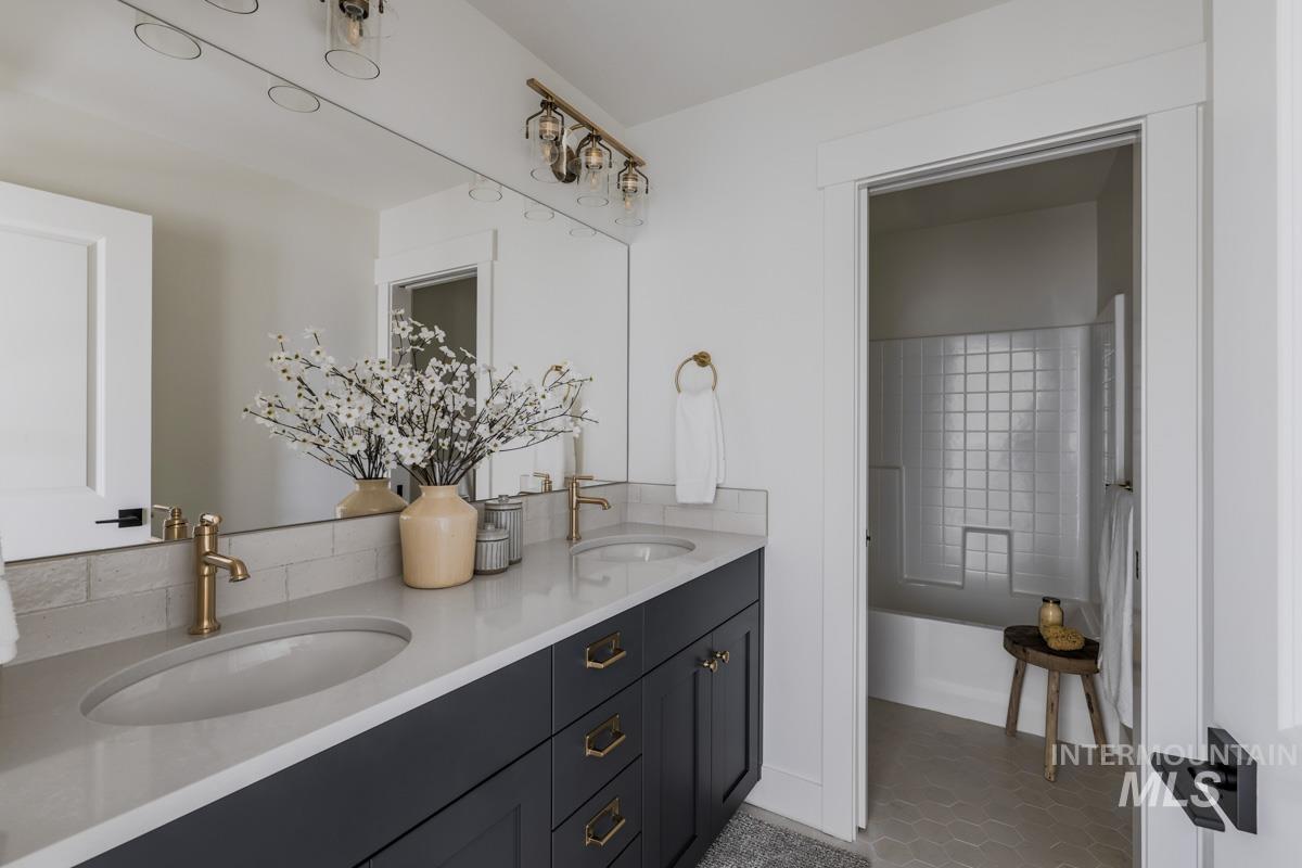 Bathroom featuring double vanity, a tub to relax in, and light tile patterned flooring