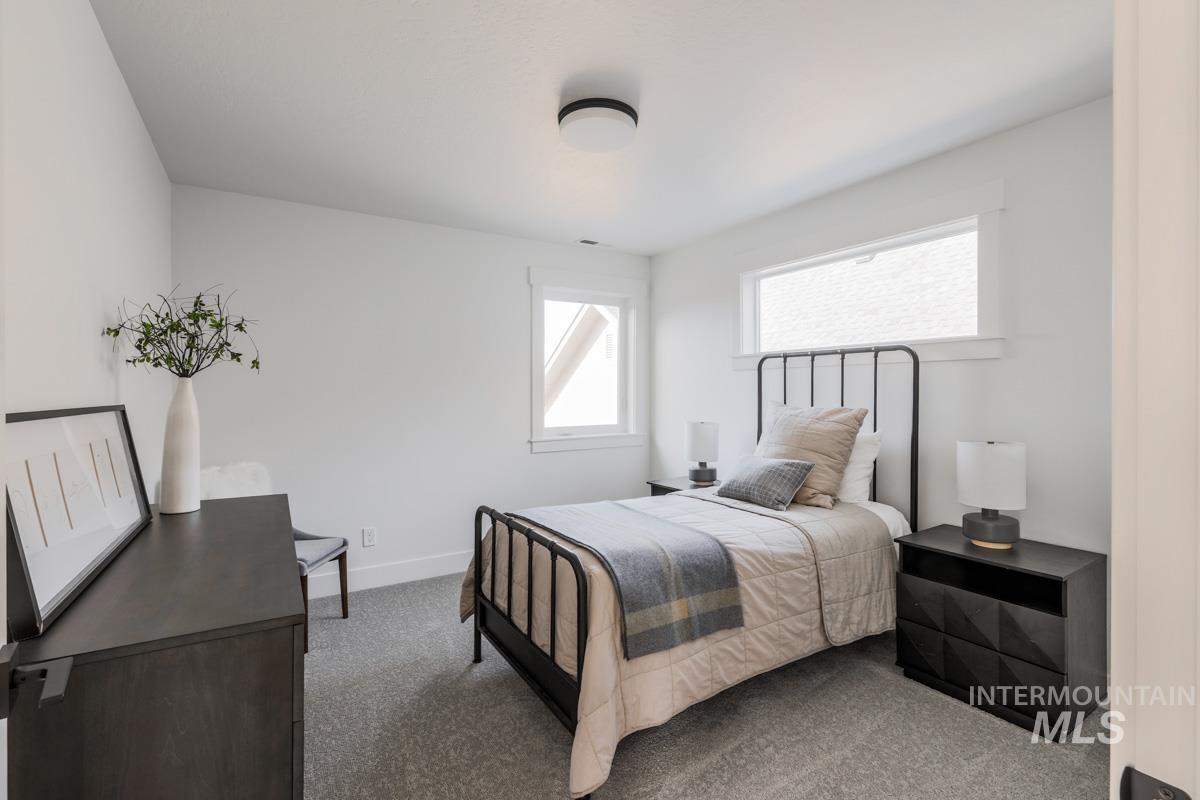 Bedroom featuring carpet and baseboards