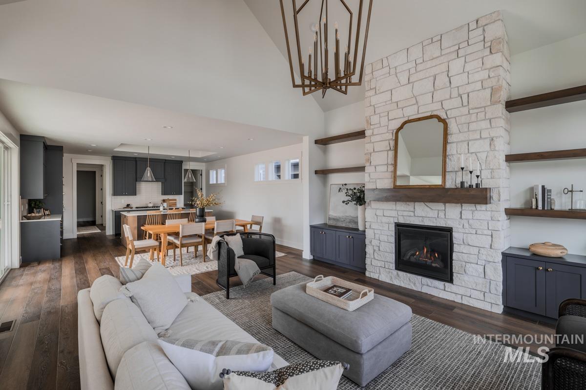 Living area with a stone fireplace and dark wood-type flooring