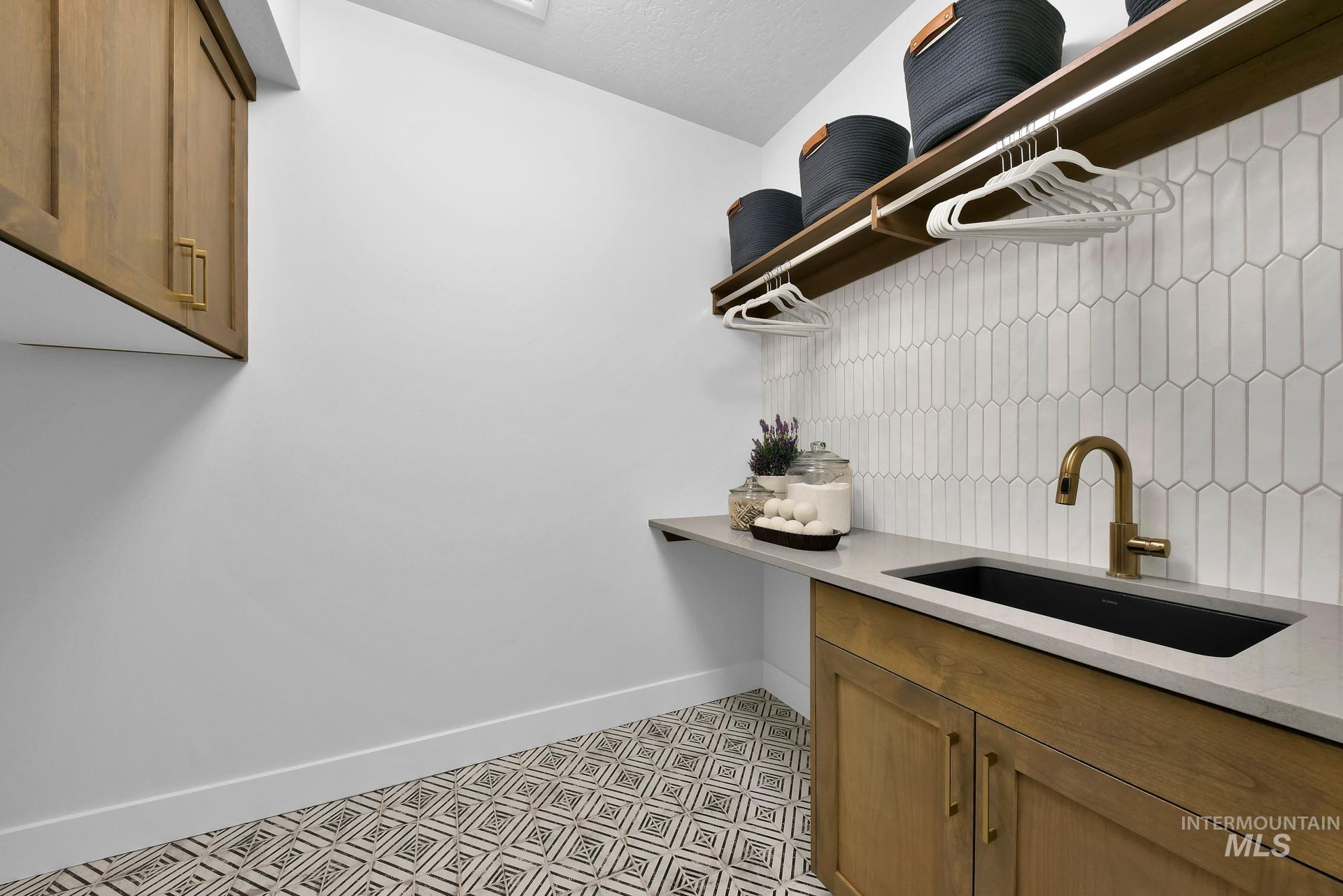Laundry room with cabinet space and baseboards