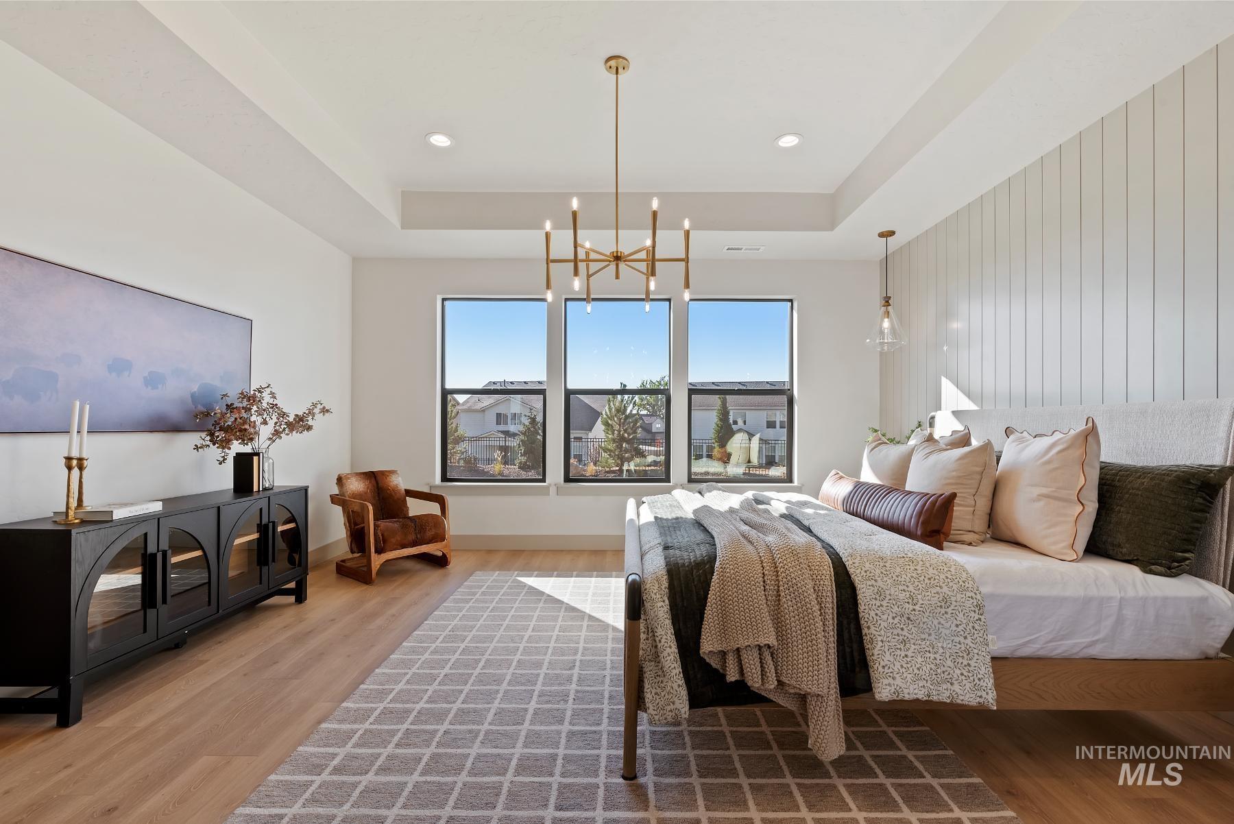 Bedroom with wood finished floors, a chandelier, recessed lighting, and a raised ceiling