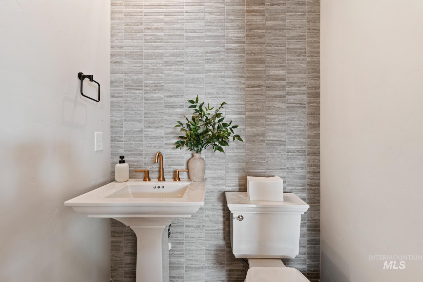 Bathroom with toilet and tile walls