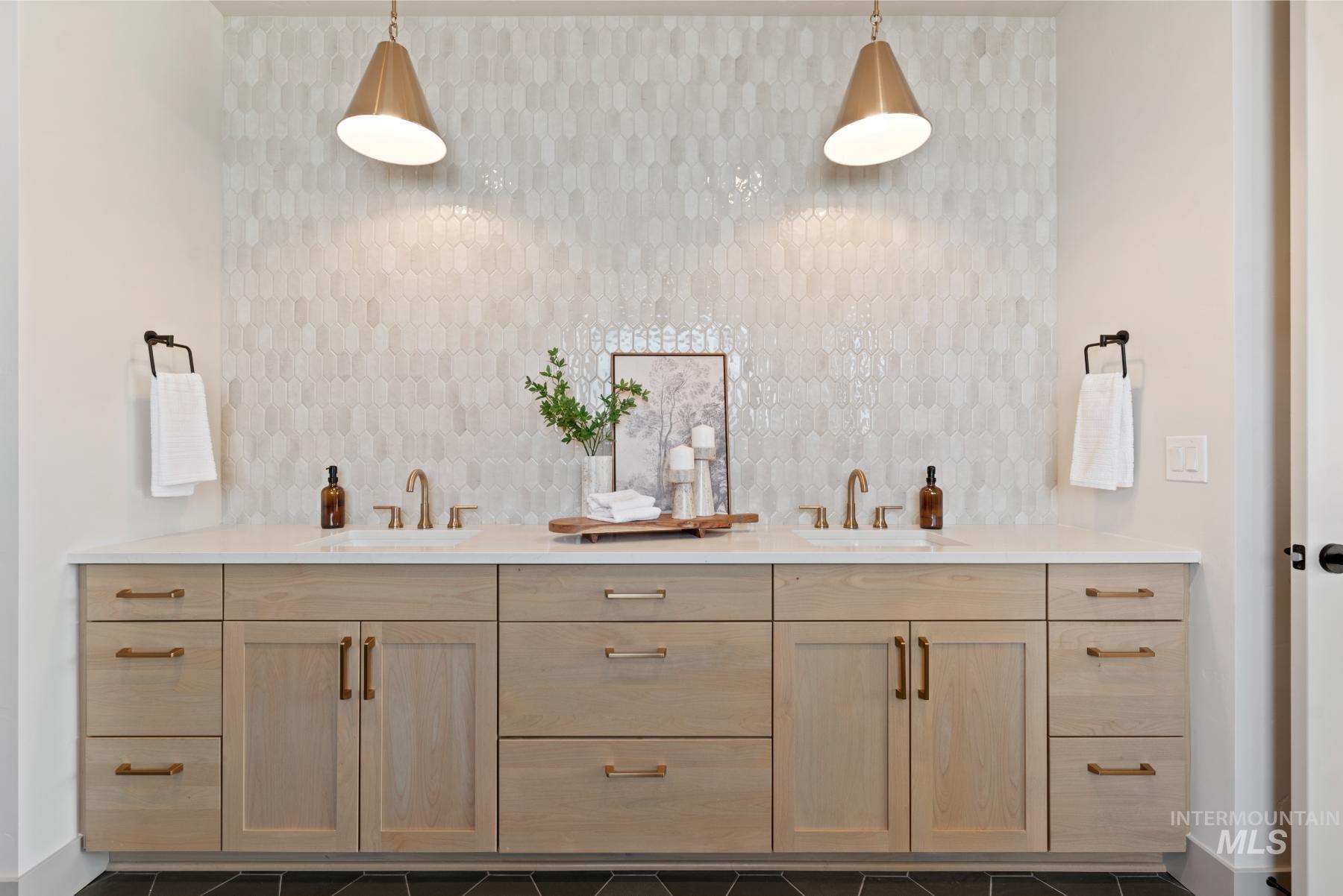 Bathroom with double vanity and baseboards