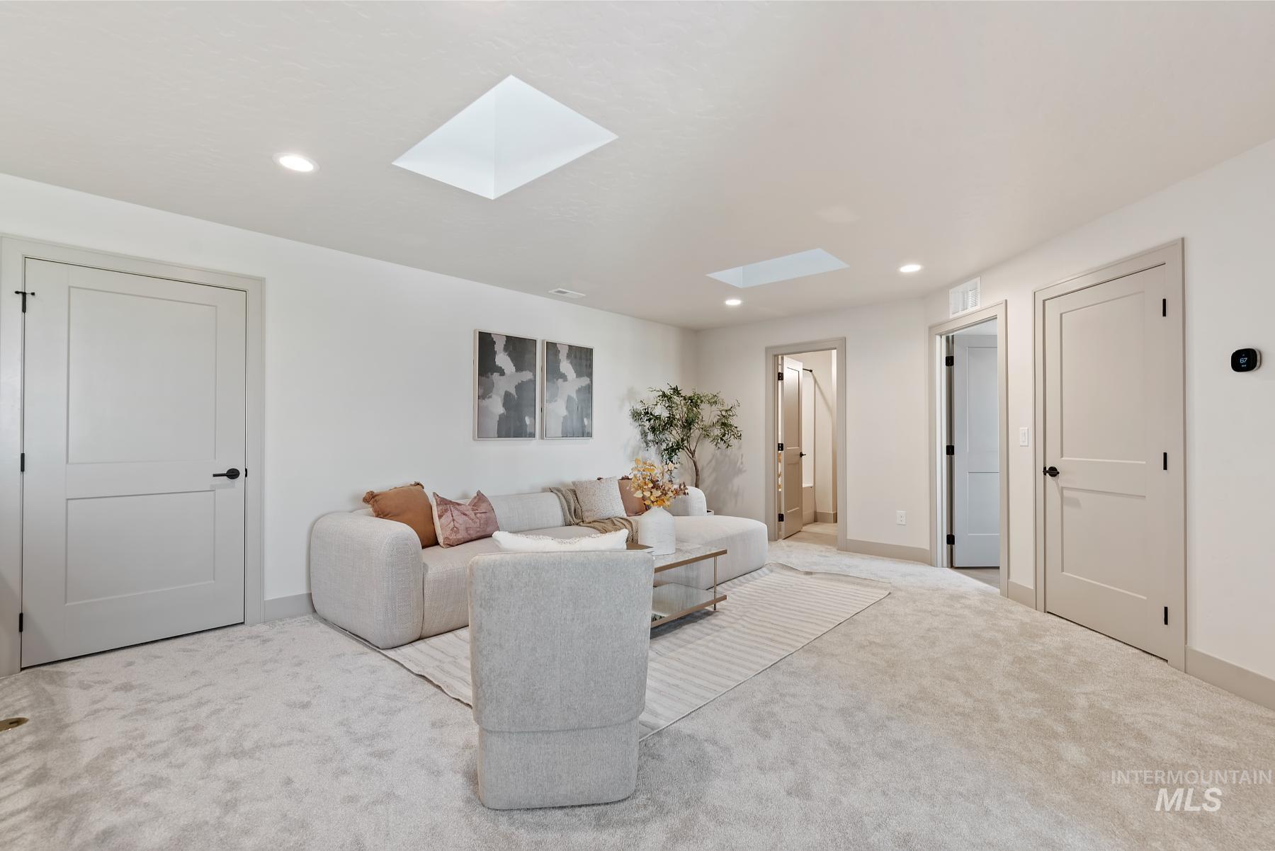 Carpeted living area with a skylight and recessed lighting