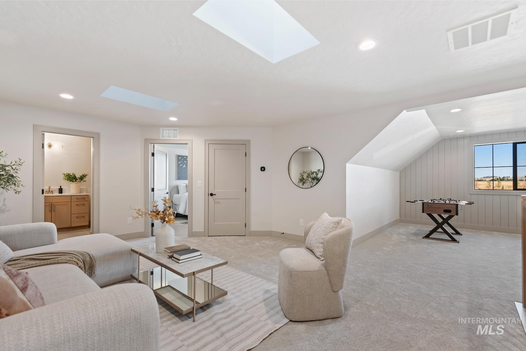 Carpeted living room with a skylight, recessed lighting, and vaulted ceiling