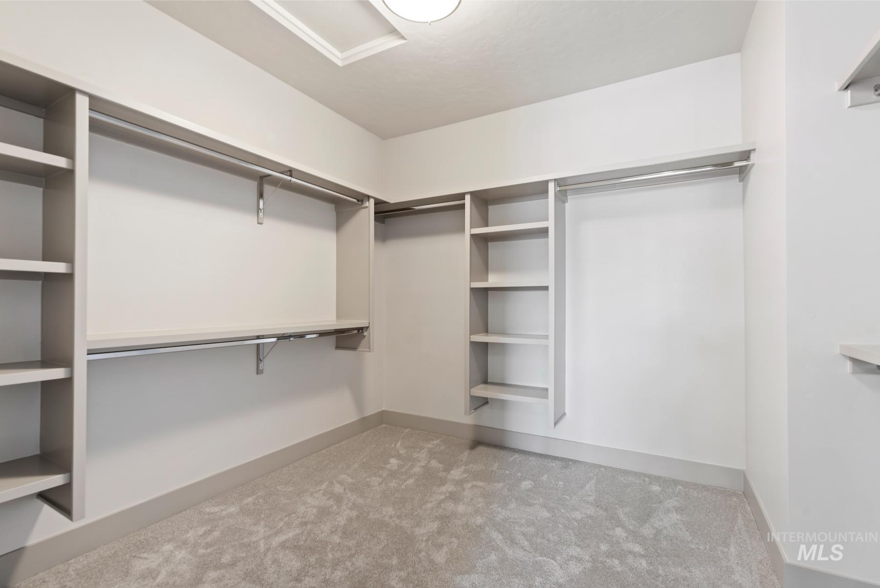 Spacious closet with light colored carpet