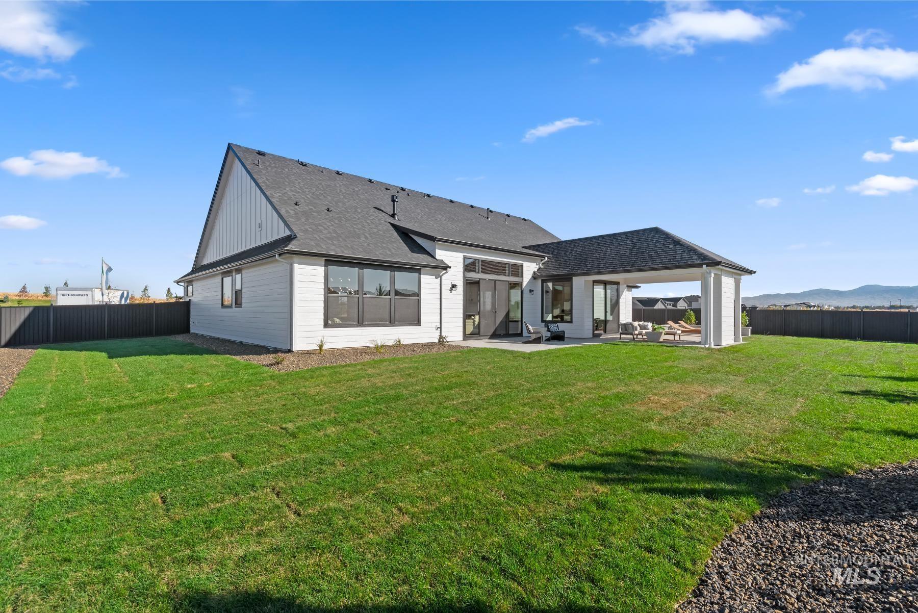 Rear view of property with a fenced backyard, a patio, roof with shingles, and a mountain view