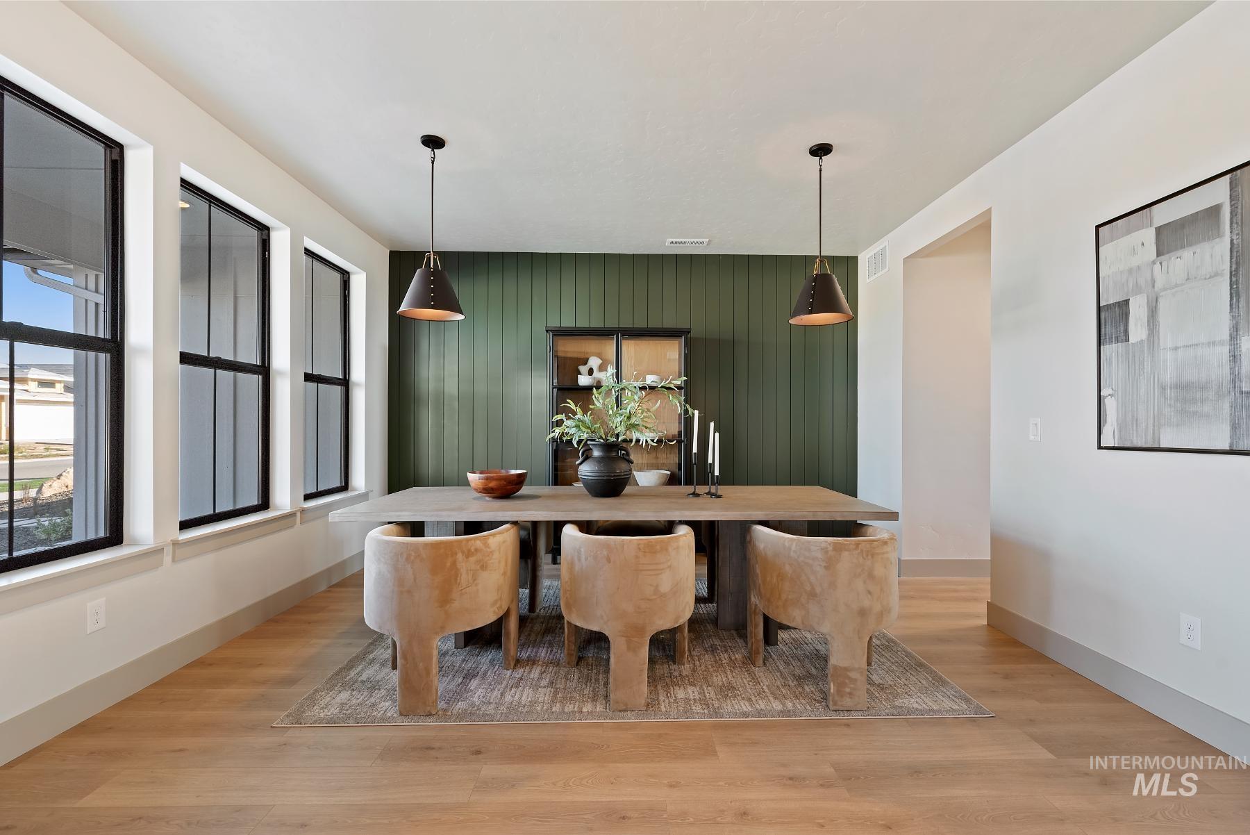 Dining room featuring light wood-type flooring and an accent wall