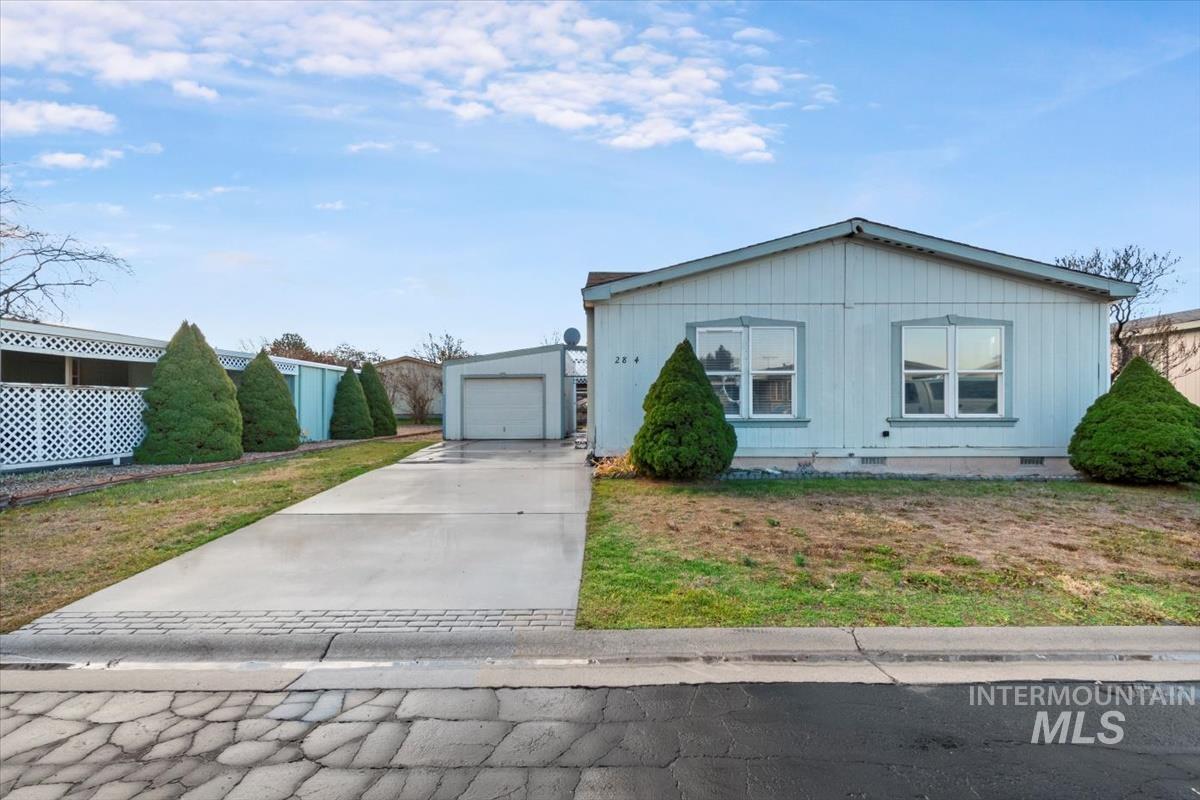 View of front facade with crawl space, driveway, a garage, and a front lawn