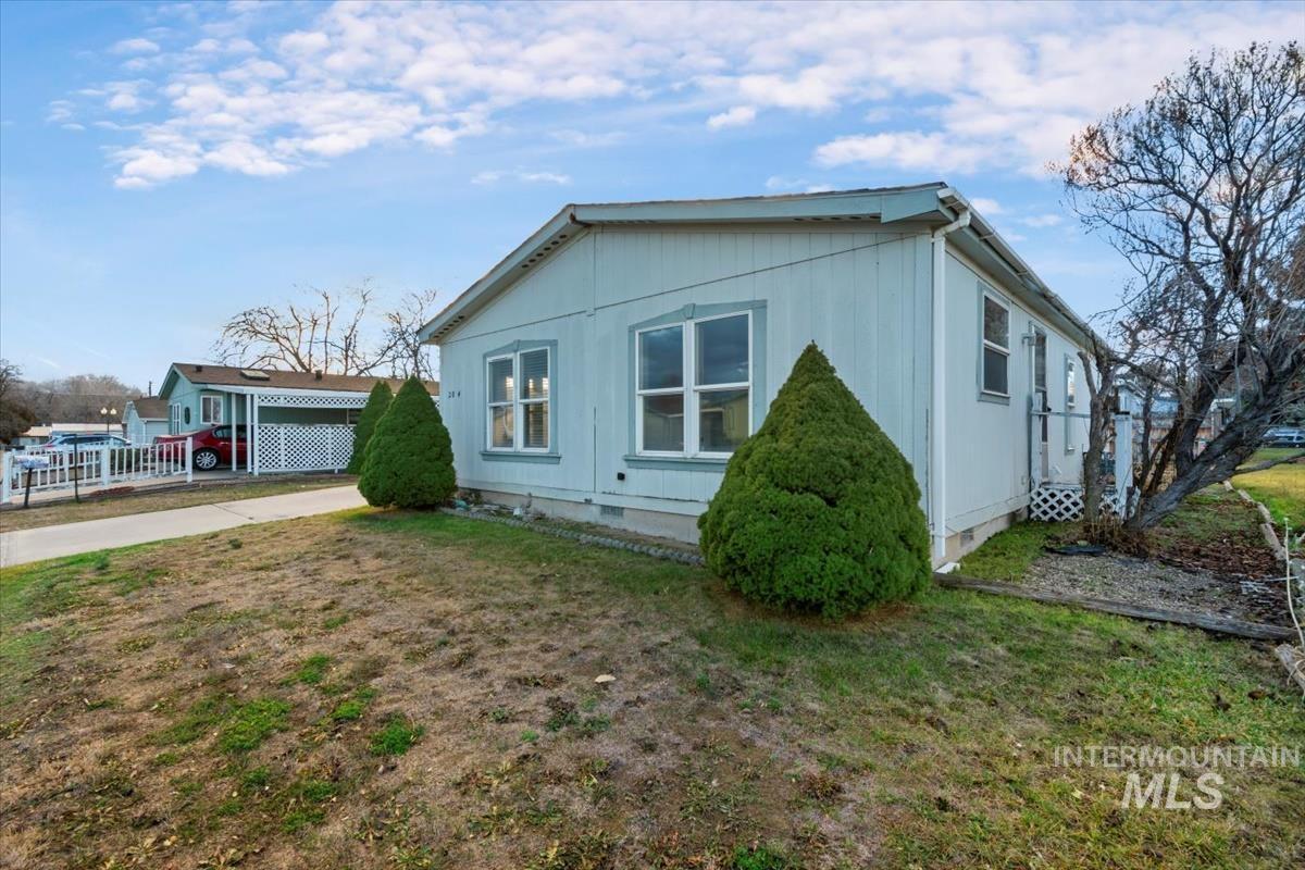 View of side of property featuring crawl space and concrete driveway