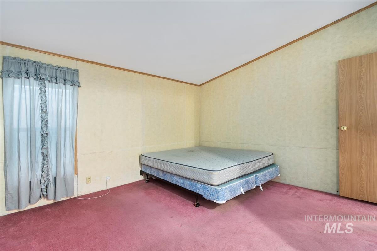 Carpeted bedroom with ornamental molding