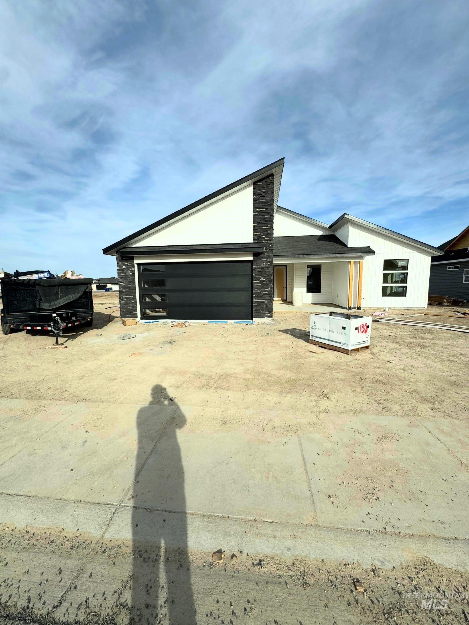 View of front of property with concrete driveway and an attached garage