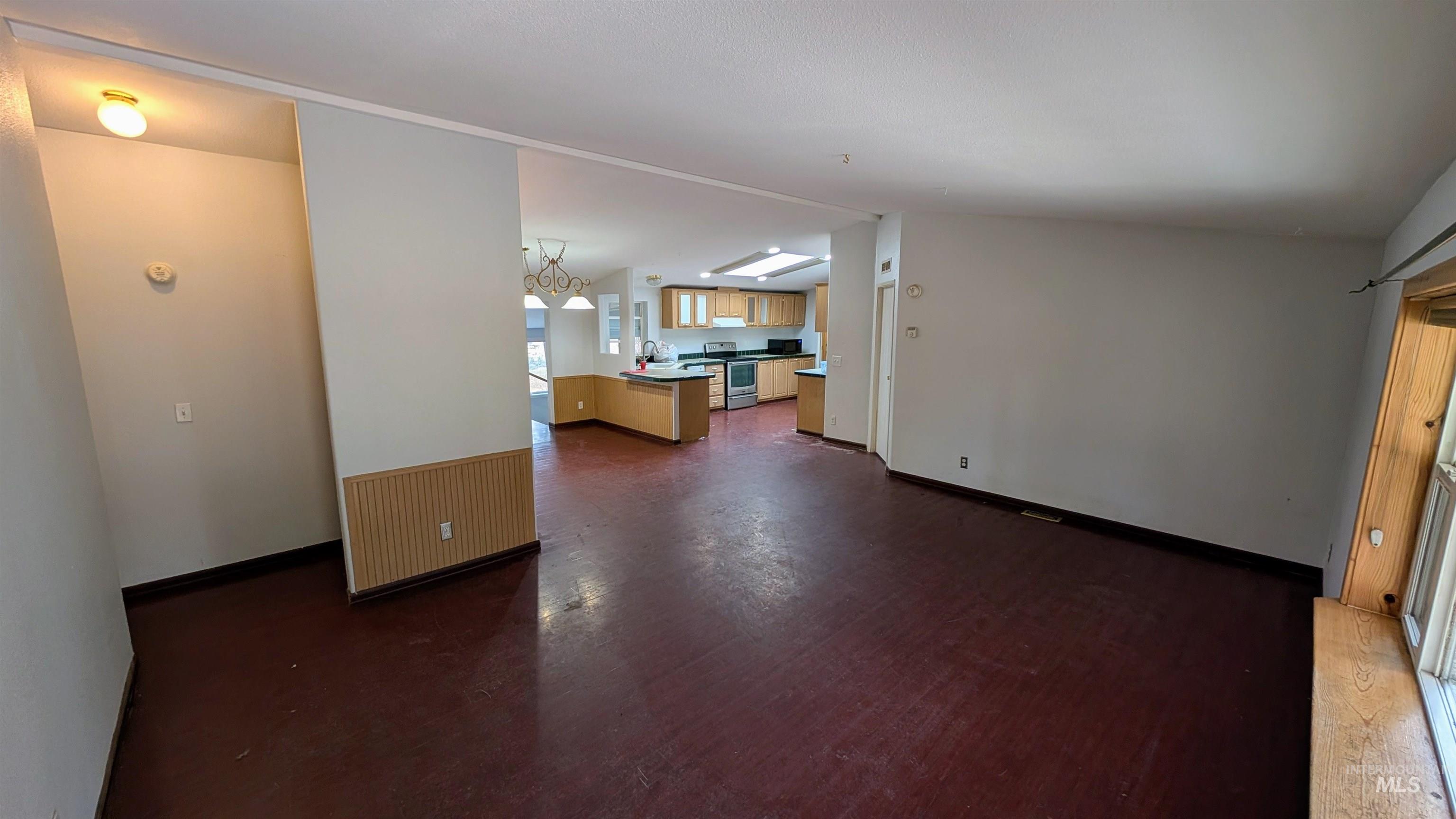 Living area featuring dark wood-style flooring and lofted ceiling