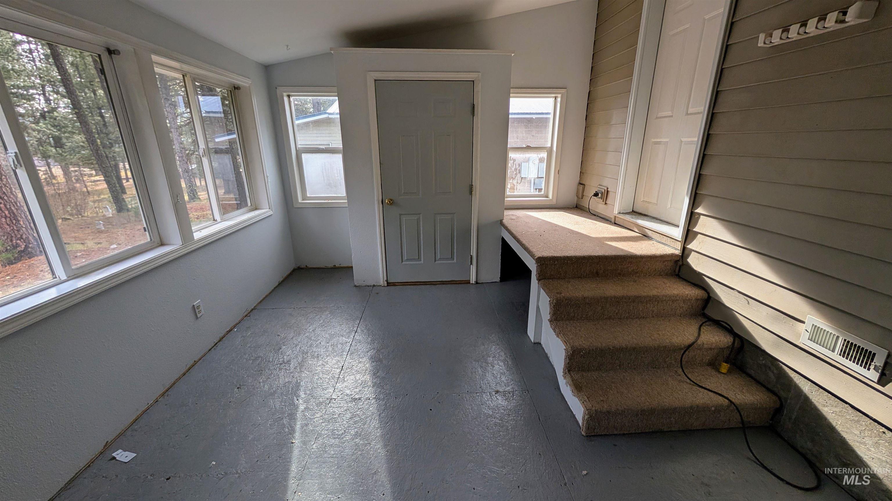 Unfurnished sunroom with vaulted ceiling
