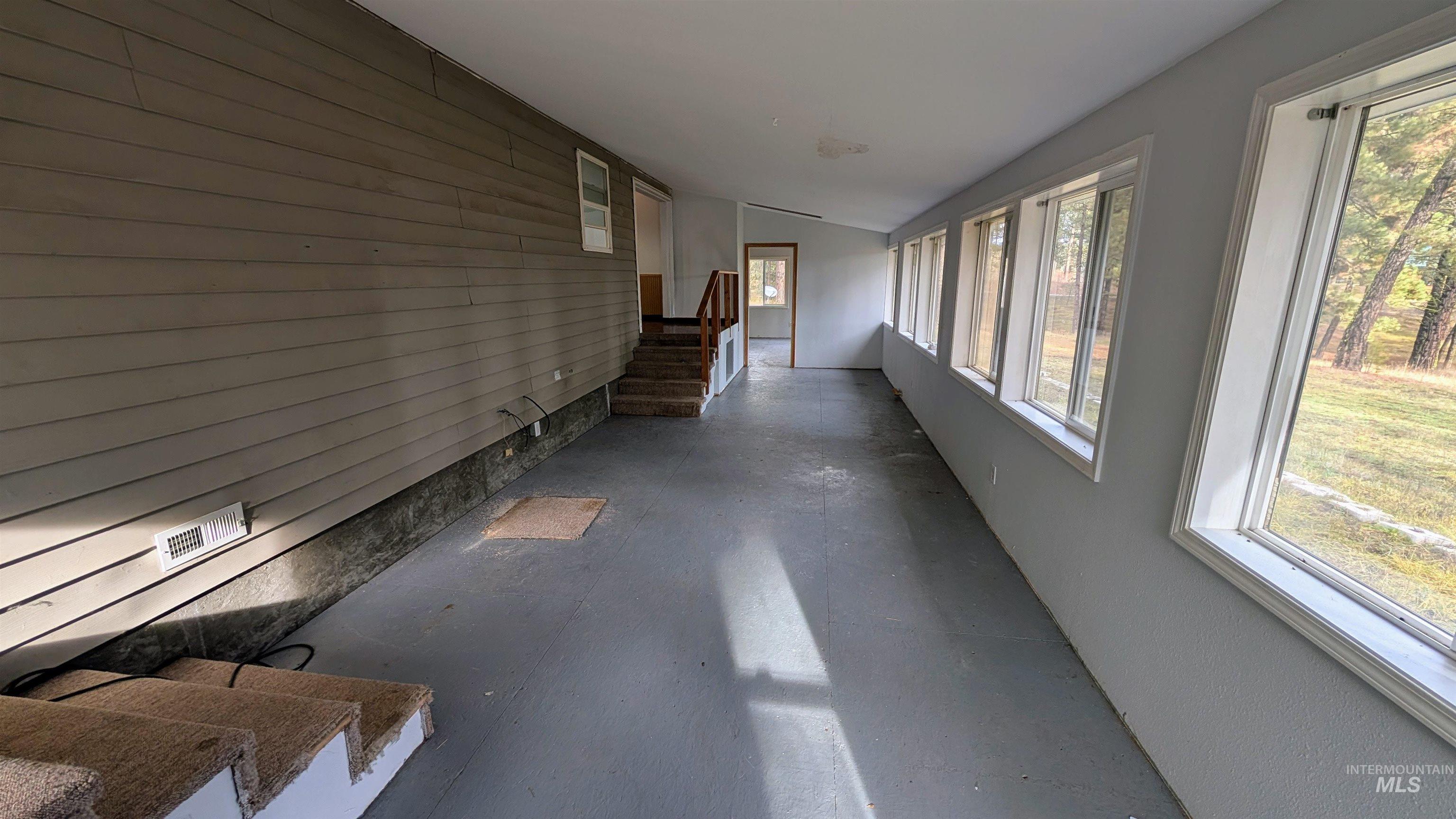 Corridor featuring stairway, wood walls, and an accent wall